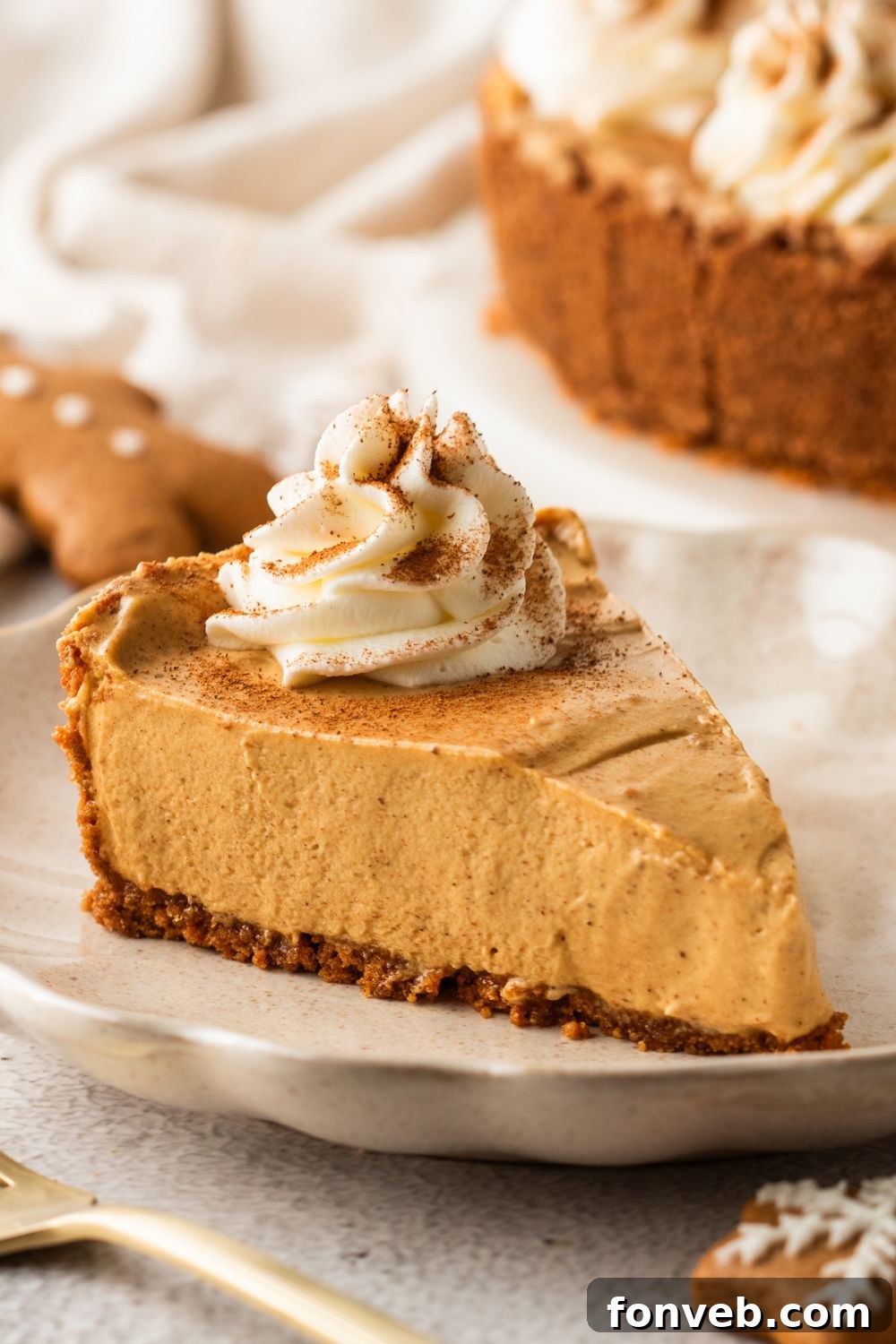 No Bake Gingerbread Cheesecake sliced on plates and placed on table with the rest of pie in the background