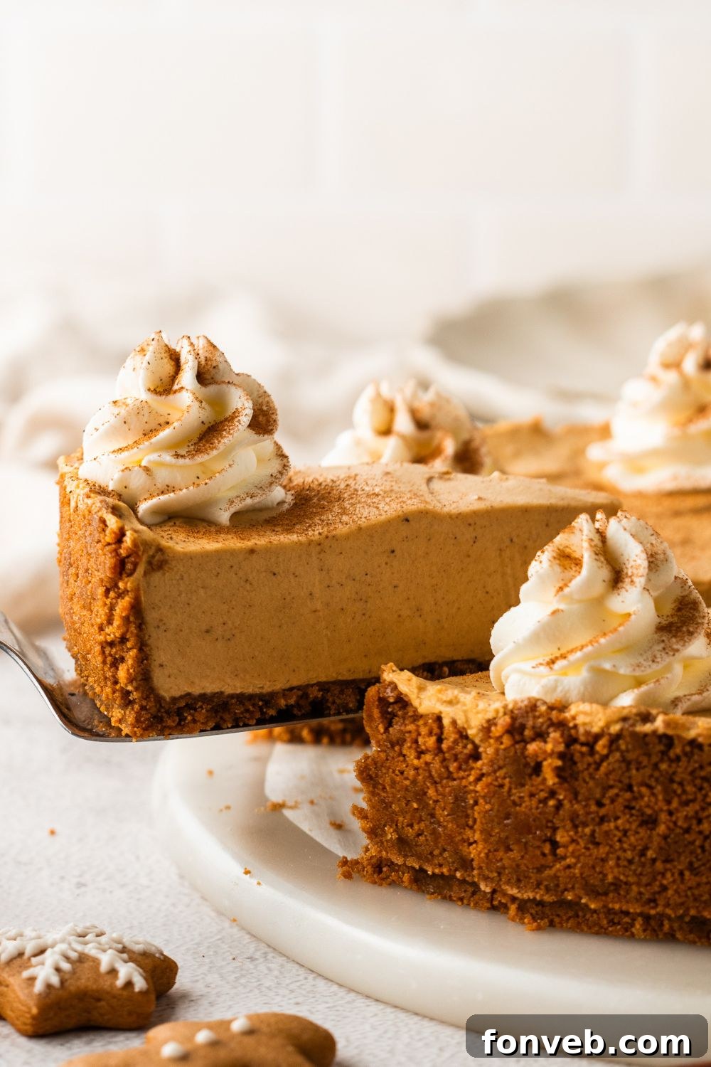 No Bake Gingerbread Cheesecake on table and a slice being lifted out of the pan