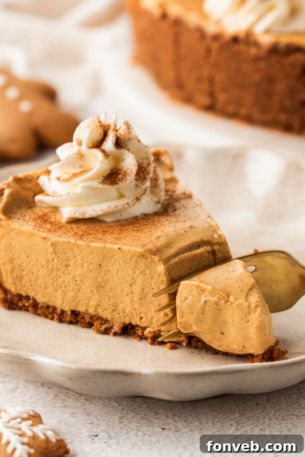 slice of No Bake Gingerbread Cheesecake on plate with a bite being cut out of it