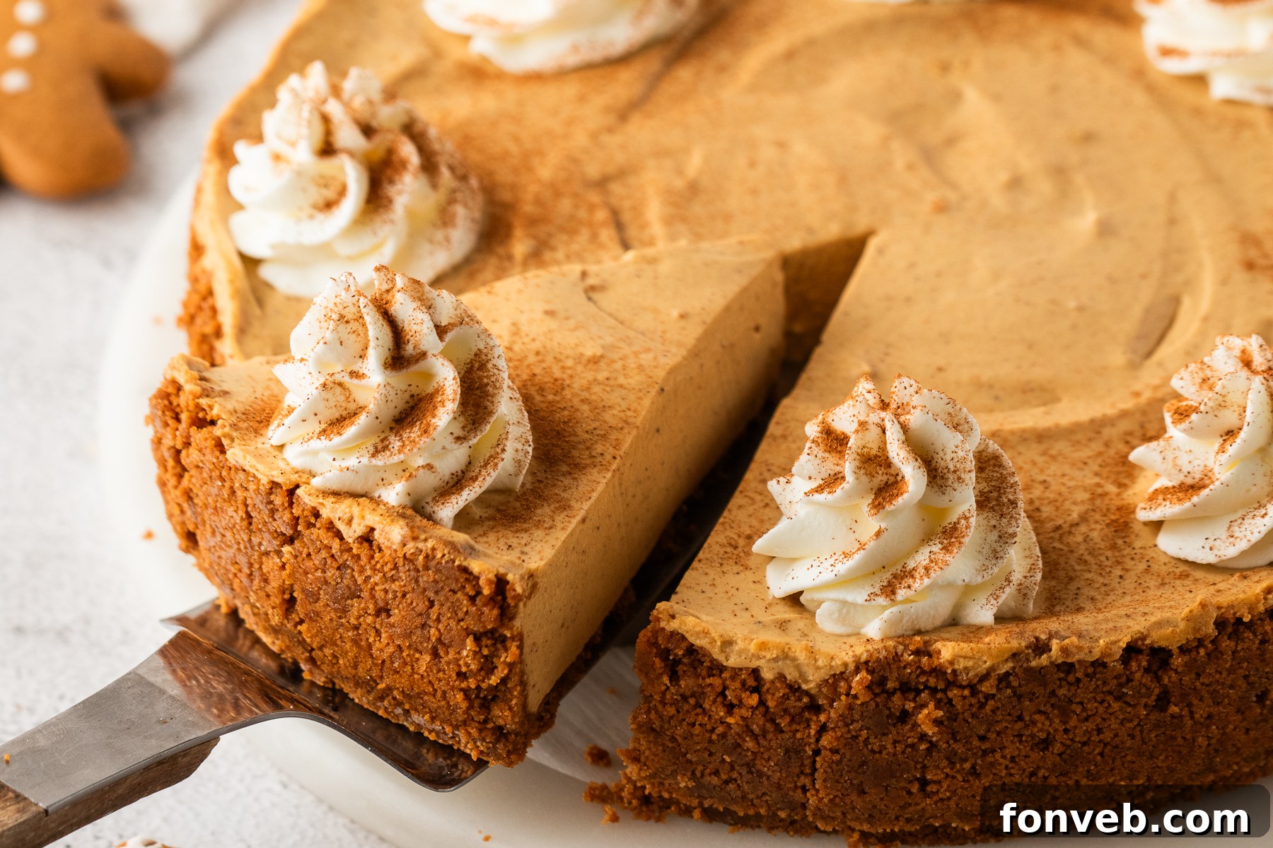 No Bake Gingerbread Cheesecake on a platter with one slice lifting out of the pie plate