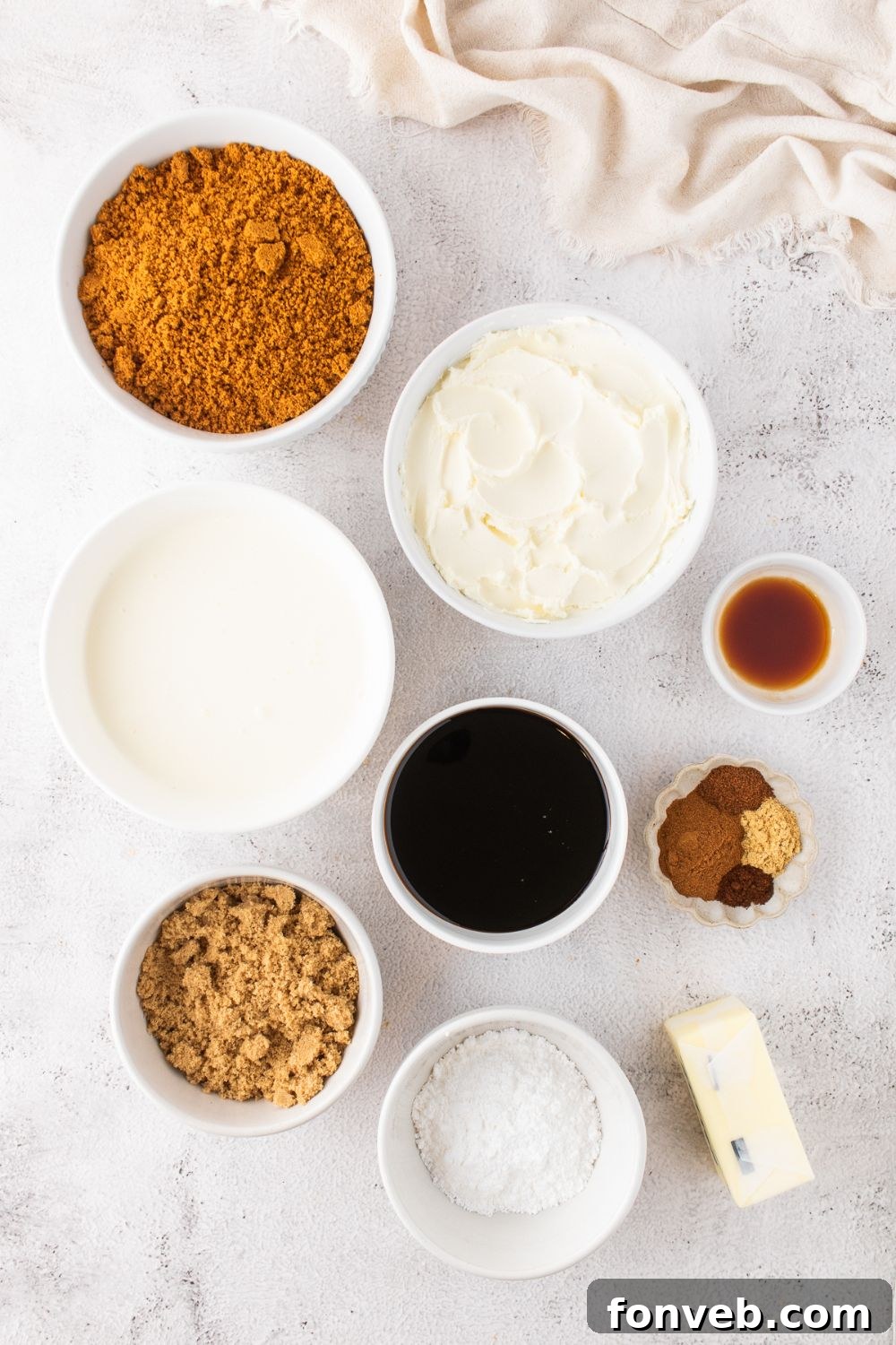 all the ingredients to make No Bake Gingerbread Cheesecake on a white table in small bowls