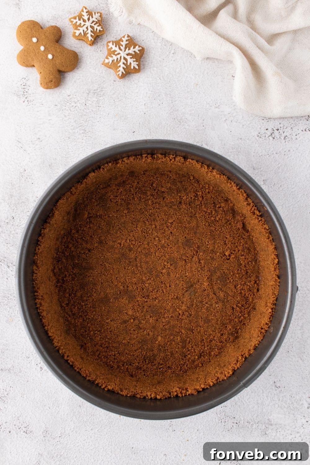 gingerbread cheesecake crust in pie pan on table