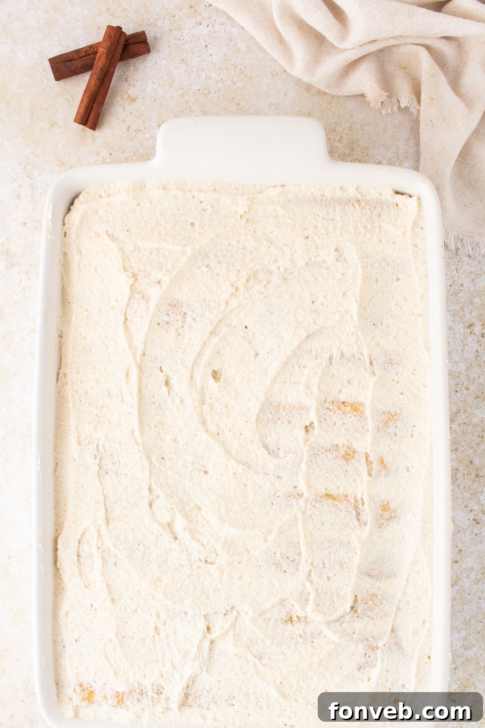 creamy topping spread on a casserole dish on table 