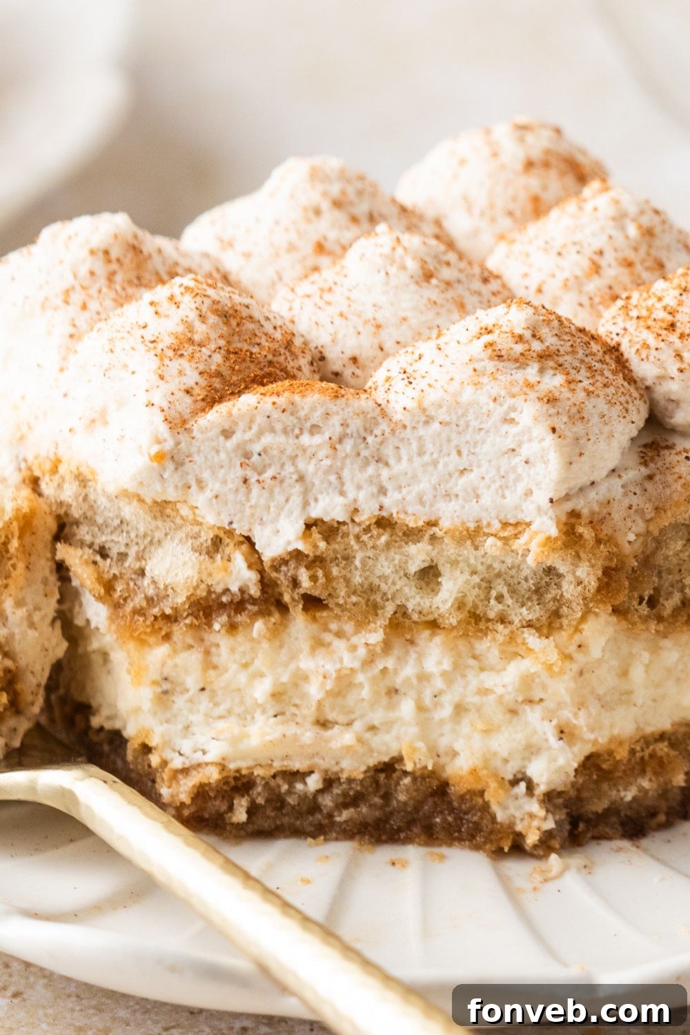 Eggnog Tiramisu on plate with a couple bites taken out of it showing the layers of the dessert 