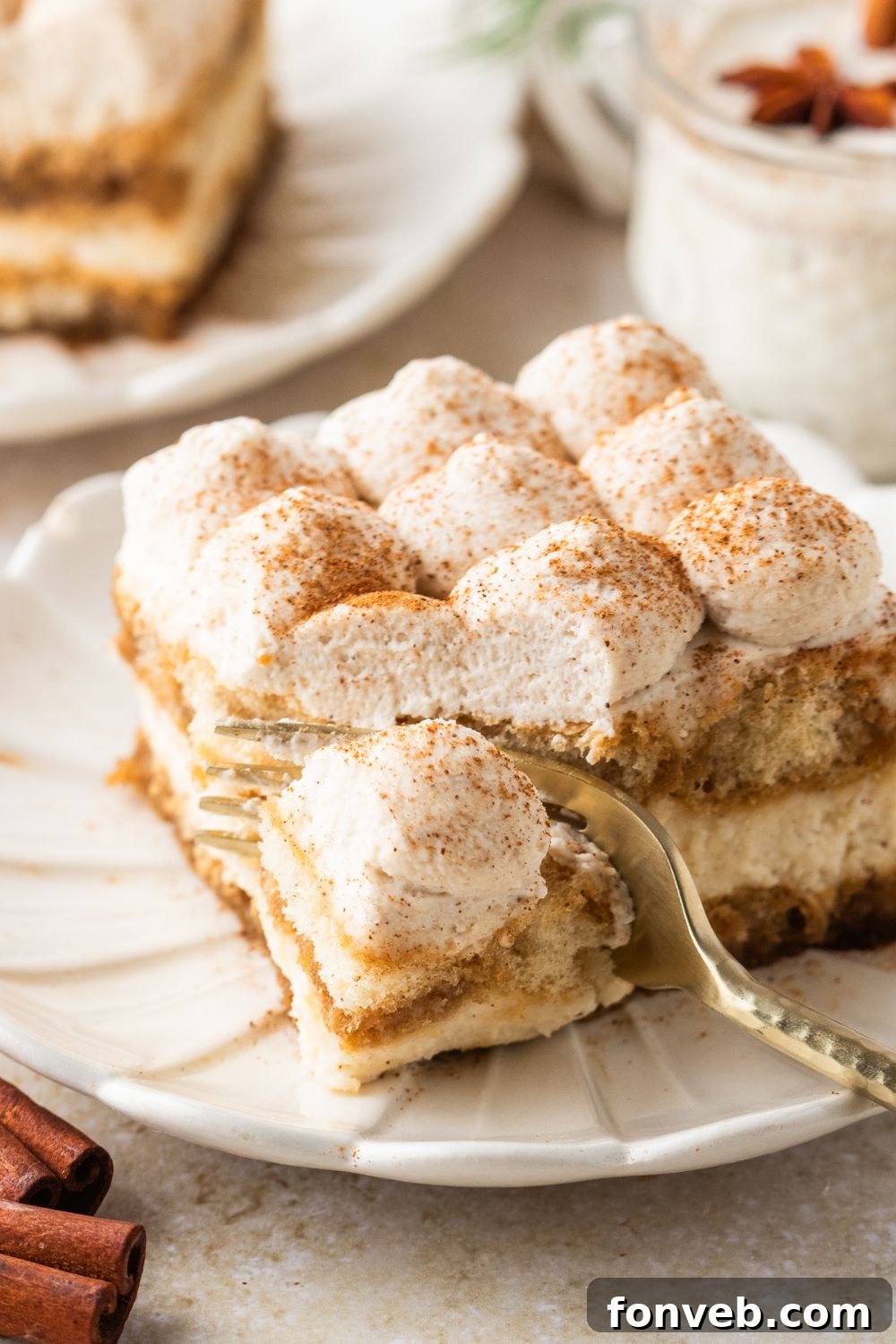 Eggnog Tiramisu on a white plate with a fork slicing into a piece of it 