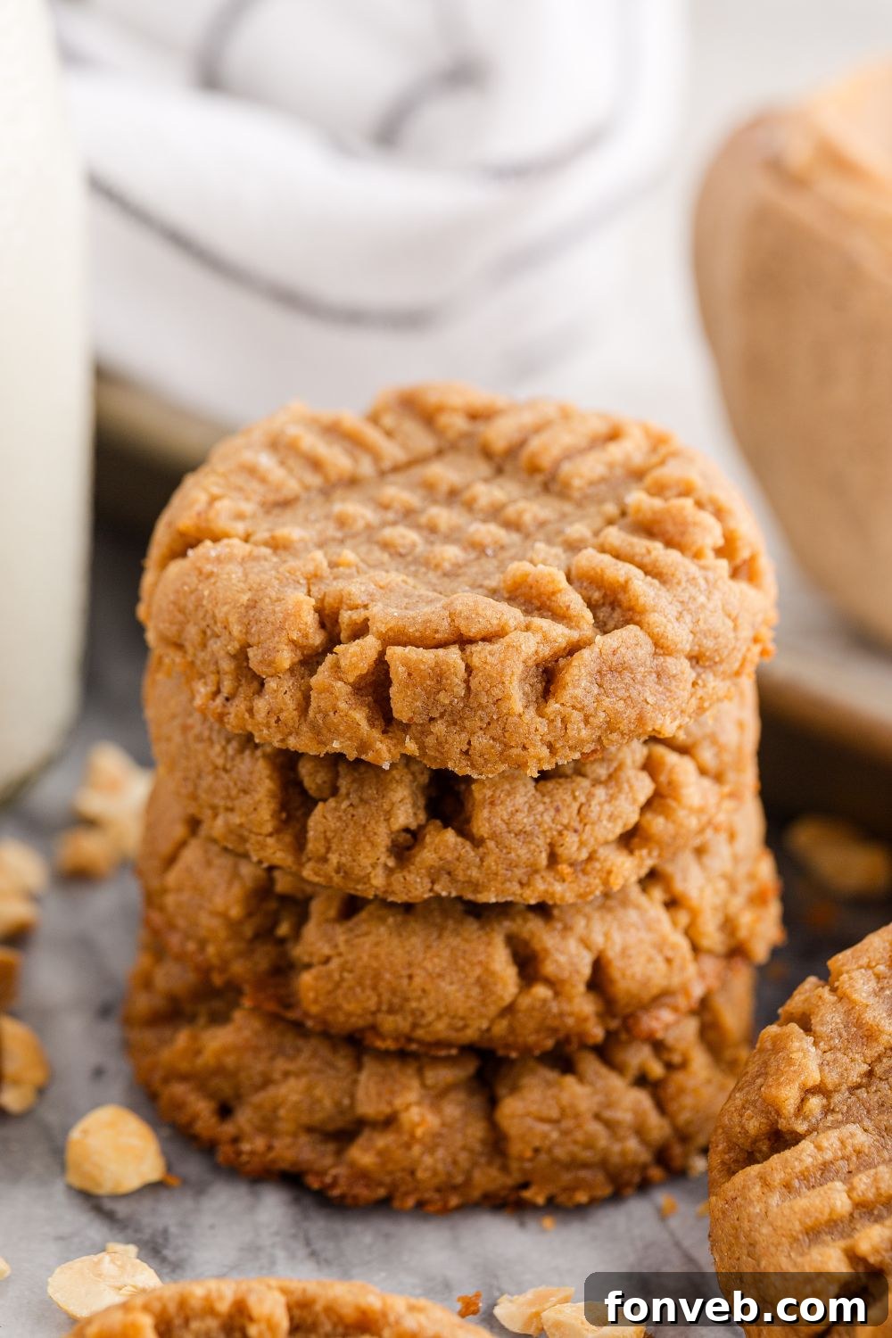 Easy 4-Ingredient Flourless Peanut Butter Cookies 14 4 Ingredient Peanut Butter Cookies stacked on a table with a glass of milk to side