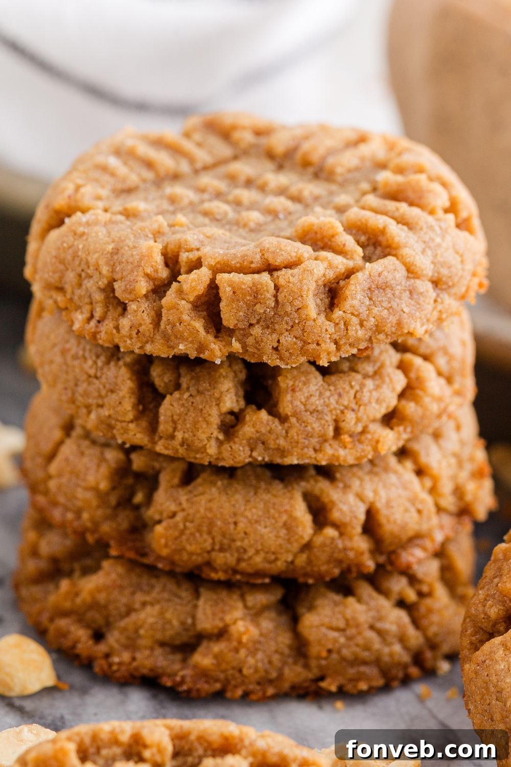 Easy 4-Ingredient Flourless Peanut Butter Cookies 20 4 Ingredient Peanut Butter Cookies stacked on the table with some nuts around the table