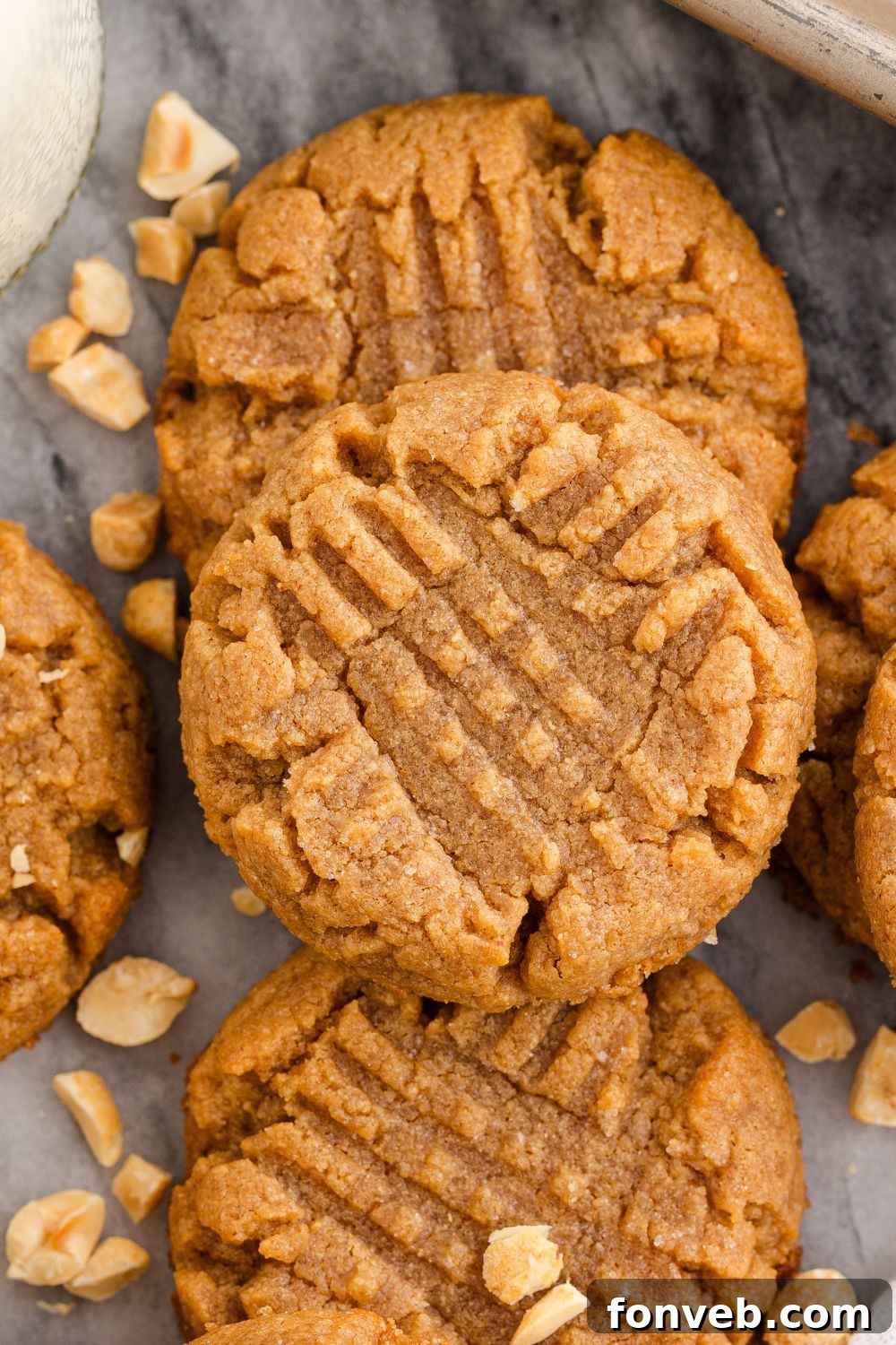 Easy 4-Ingredient Flourless Peanut Butter Cookies 4 close up of peanut butter cookies on a marble counter with peanuts around the table