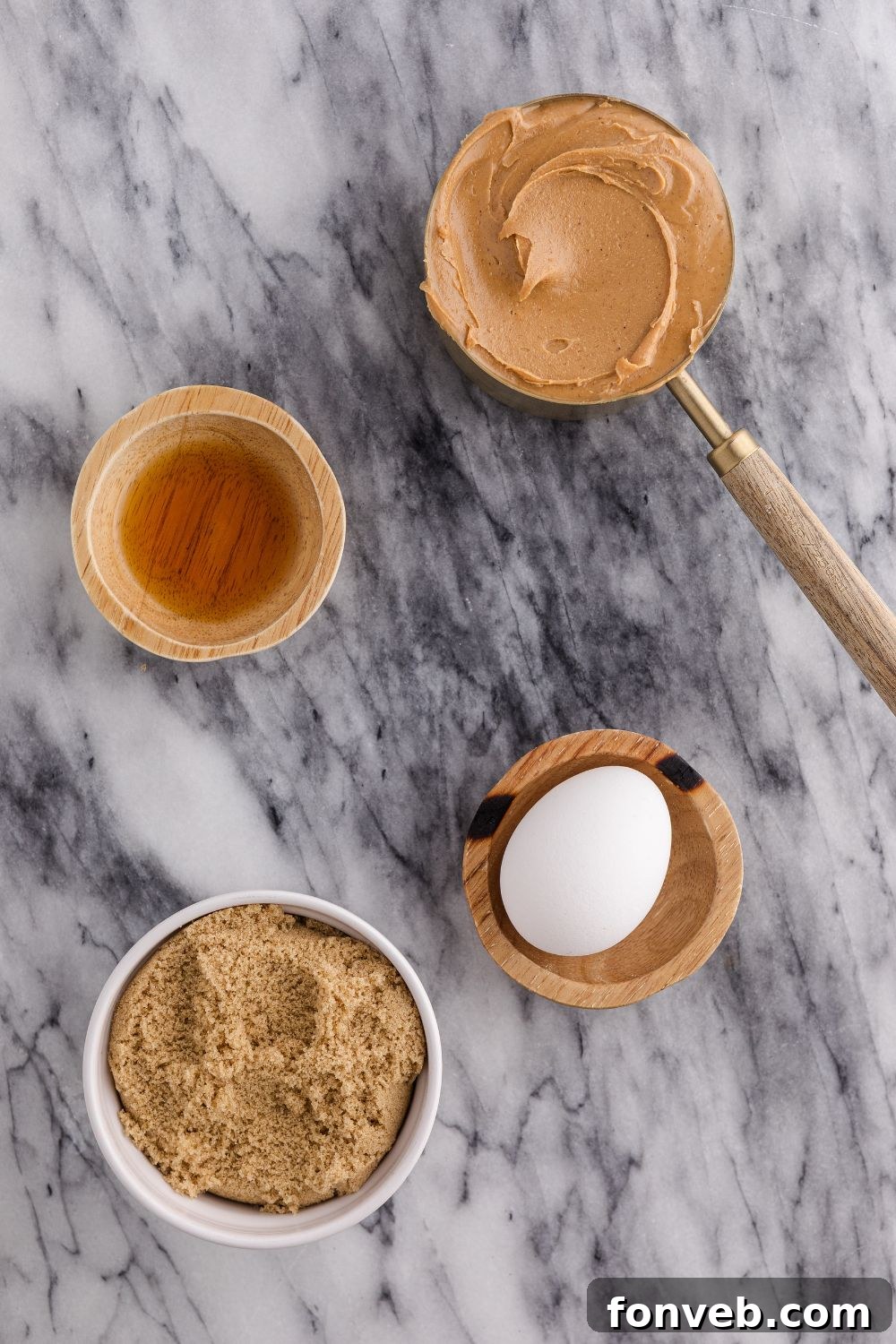 Easy 4-Ingredient Flourless Peanut Butter Cookies 5 all the ingredients for making 4 Ingredient Peanut Butter Cookies on a marble counter