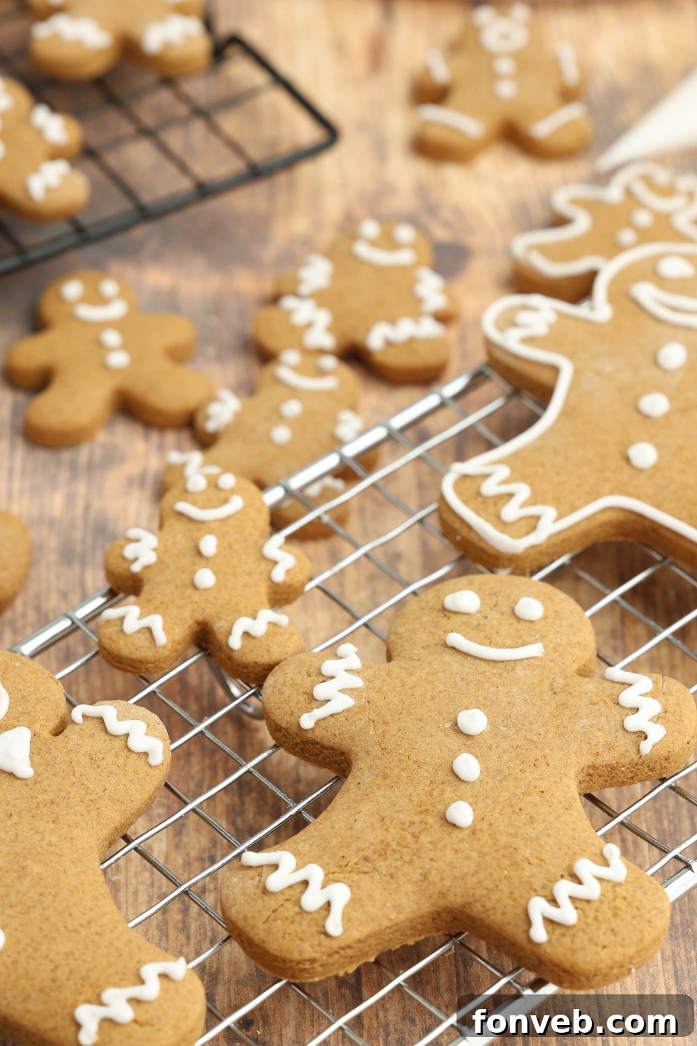 Dazzling Christmas Gingerbread Adorned With Royal Icing 20 different sized gingerbread on a cooling rack on table