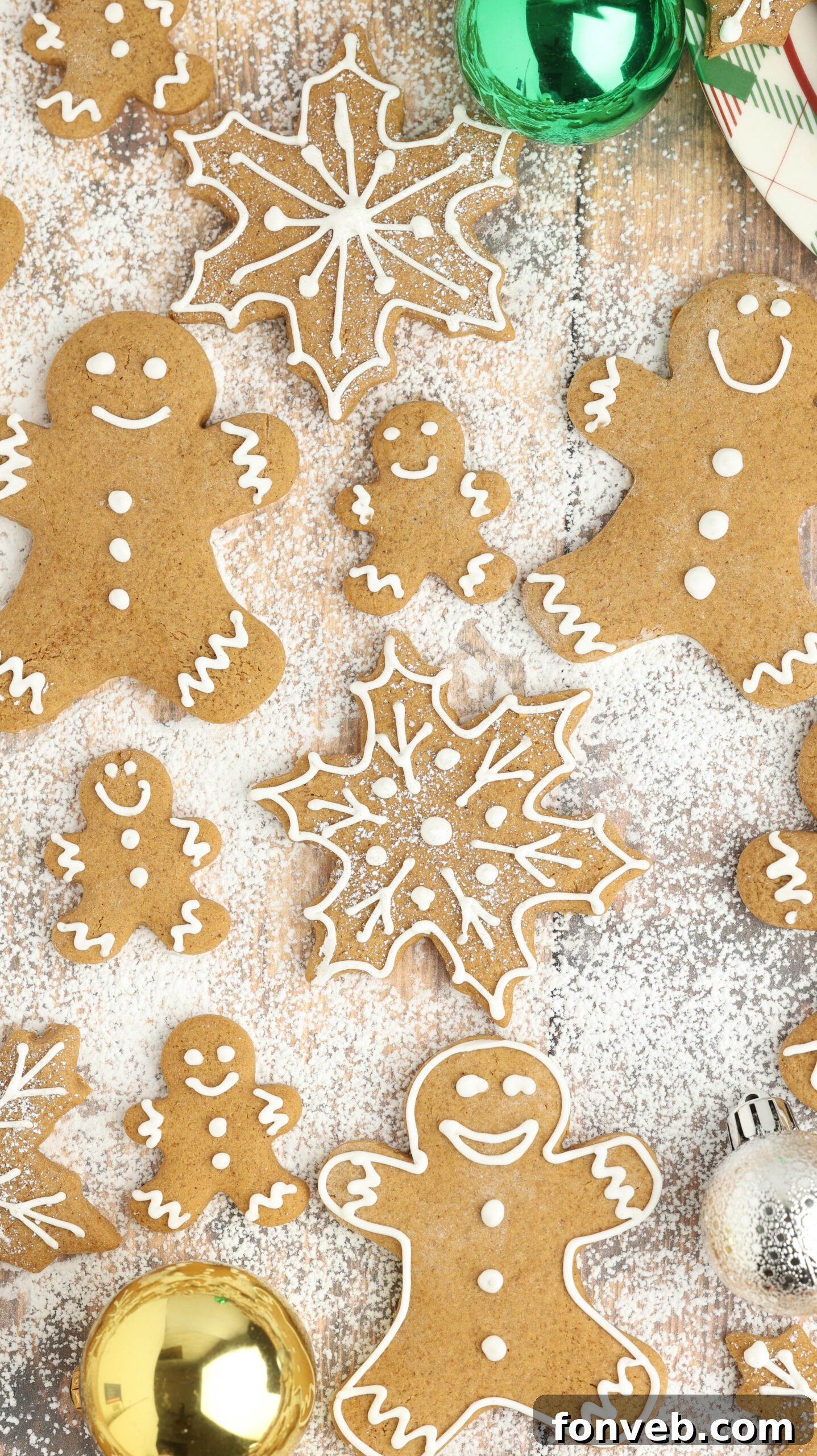 Dazzling Christmas Gingerbread Adorned With Royal Icing 21 a table full of Christmas gingerbread cookies all over and different shapes laying in powdered sugar
