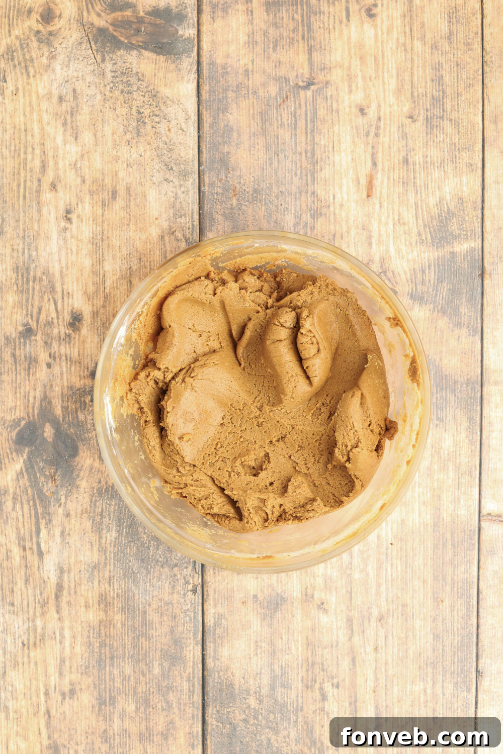 Dazzling Christmas Gingerbread Adorned With Royal Icing 5 glass bowl of Christmas gingerbread cookie batter on a wooden table