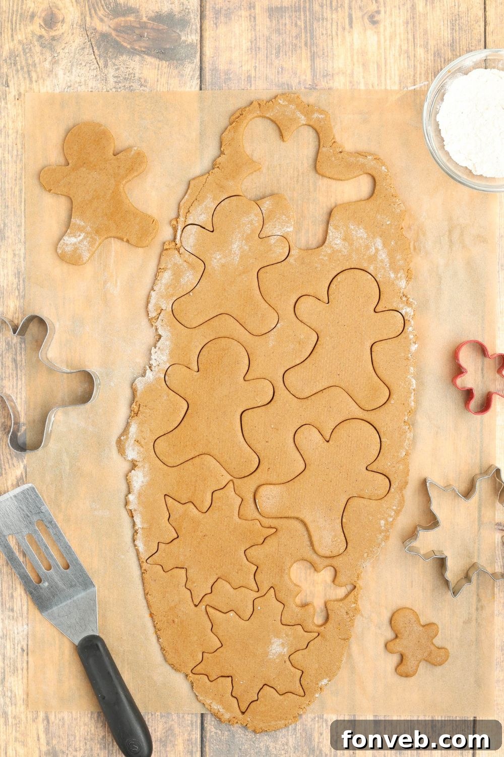 Dazzling Christmas Gingerbread Adorned With Royal Icing 7 rolled out cookie dough on table with gingerbread cutouts