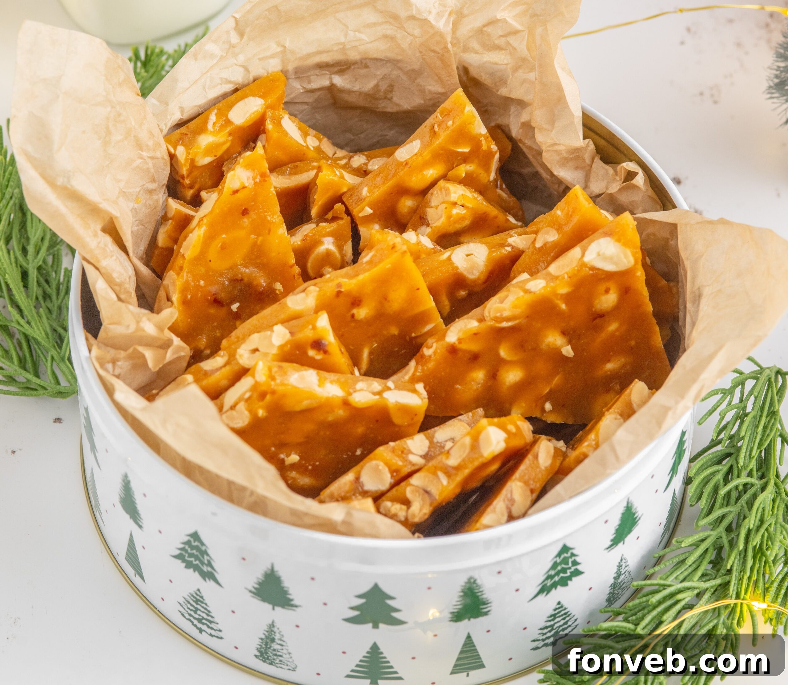 Classic Crunchy Peanut Brittle Made Simple 2 Homemade Peanut Brittle in a Christmas tin on table with Christmas decor