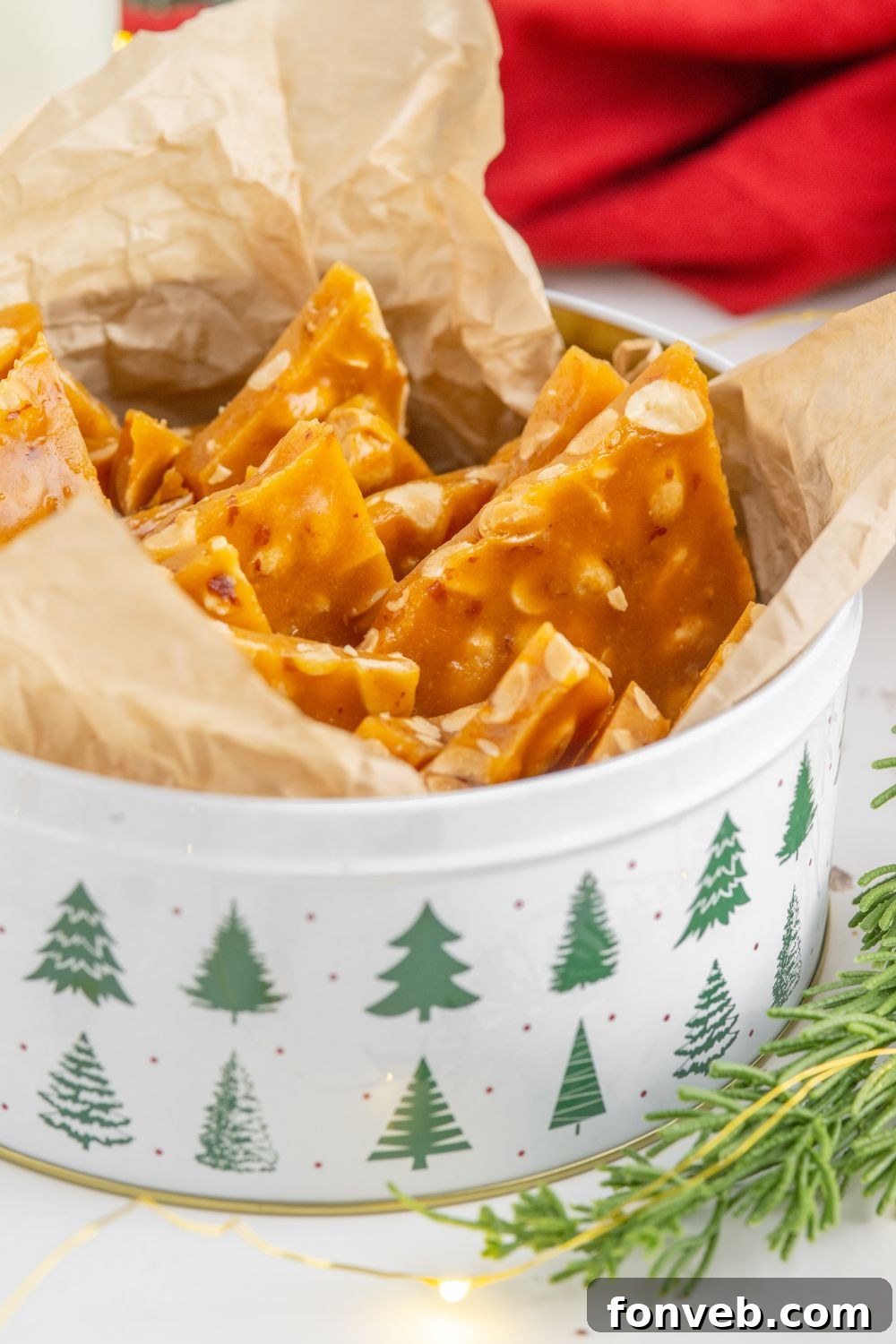 Classic Crunchy Peanut Brittle Made Simple 14 Homemade Peanut Brittle in a Christmas tin on a white counter