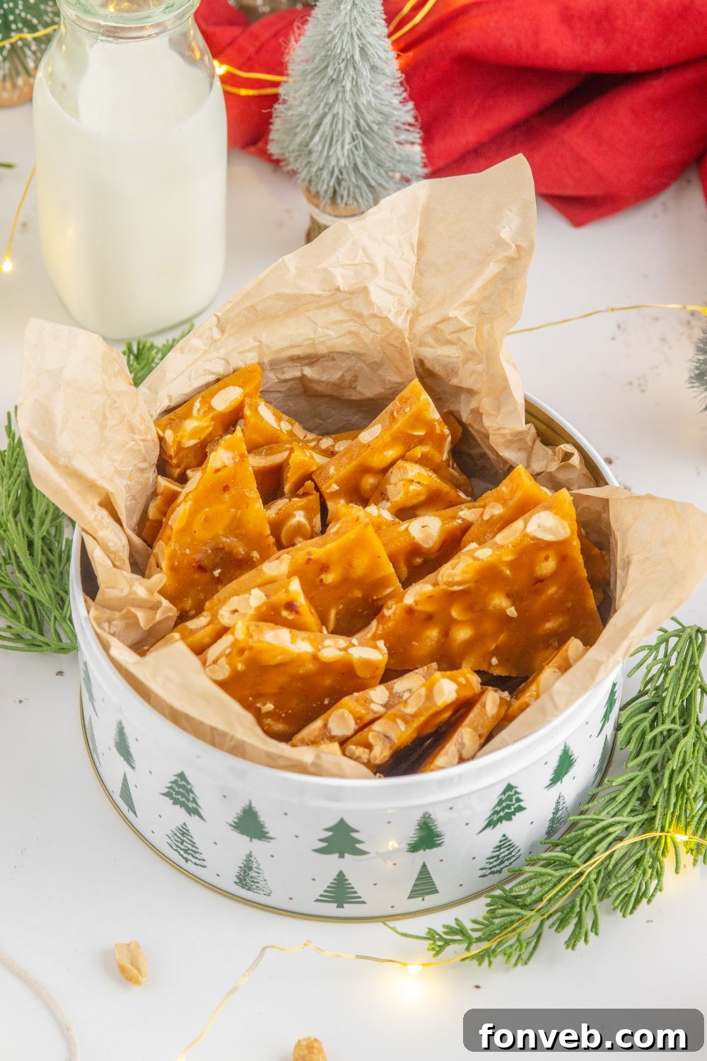 Classic Crunchy Peanut Brittle Made Simple 19 tin full of peanut brittle with a red towel behind it