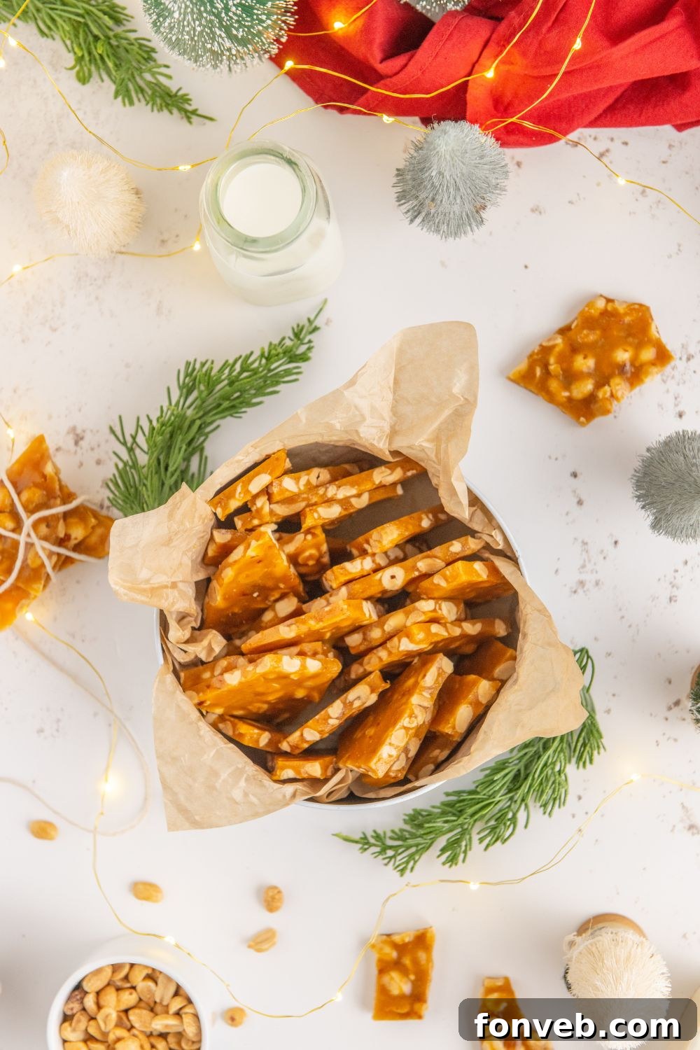 Classic Crunchy Peanut Brittle Made Simple 20 tin on white table with Christmas decor full of Homemade Peanut Brittle