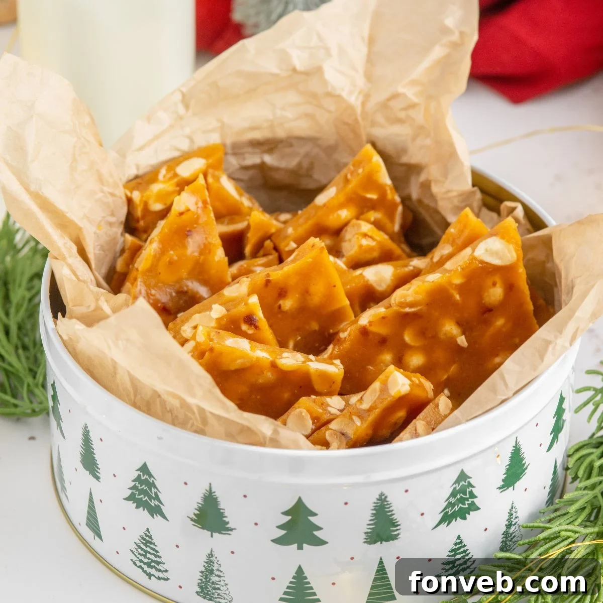 Classic Crunchy Peanut Brittle Made Simple 21 Homemade Peanut Brittle in a Christmas tin on table with Christmas decor