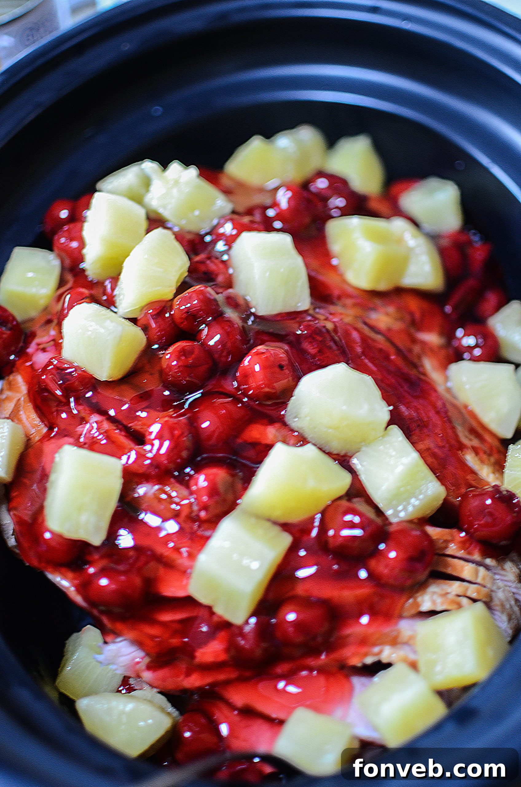 Slow Cooker Caramelized Pineapple Ham 5 Cooked slow cooker ham with a rich, glossy glaze and visible pineapple chunks.