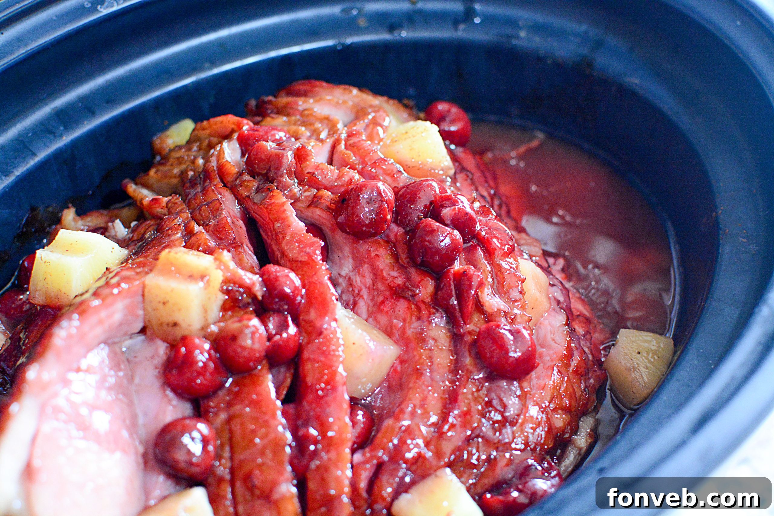 Slow Cooker Caramelized Pineapple Ham 7 Deliciously glazed ham slices with pineapple rings and cherries, close-up.