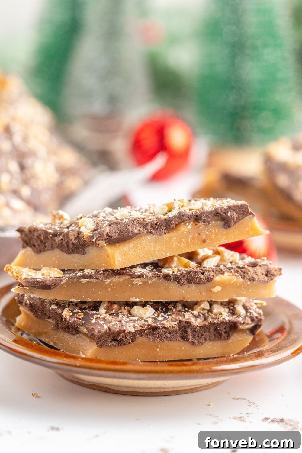 English Toffee stacked on a plate with more around the background with Christmas decor 