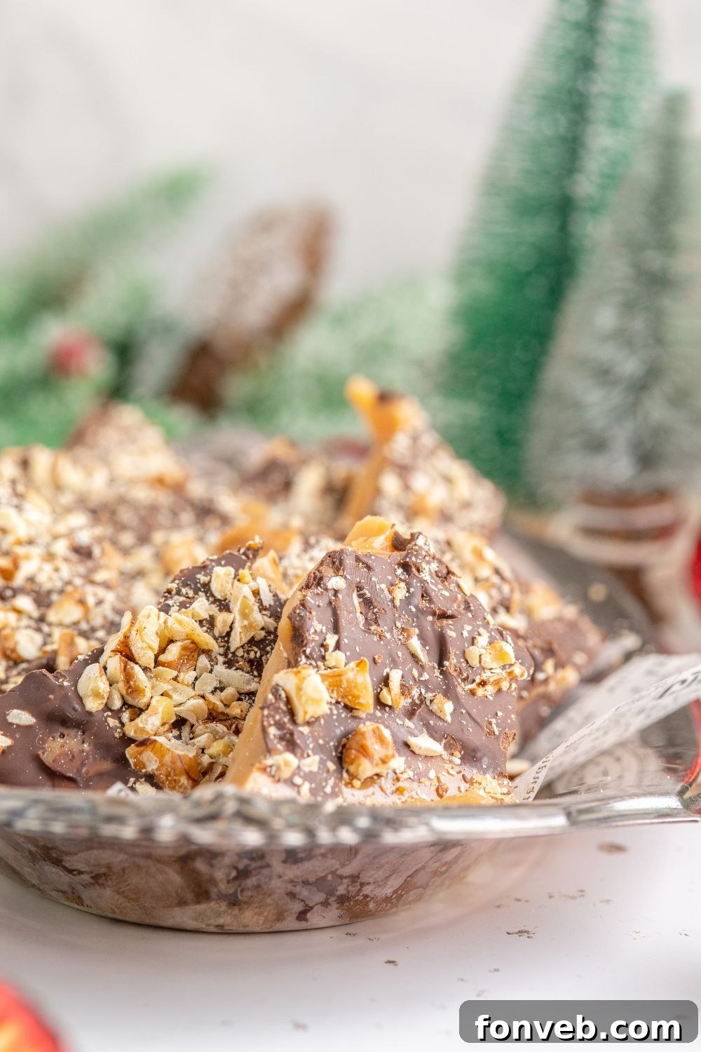 English Toffee on a silver platter with Christmas trees behind it on the table 