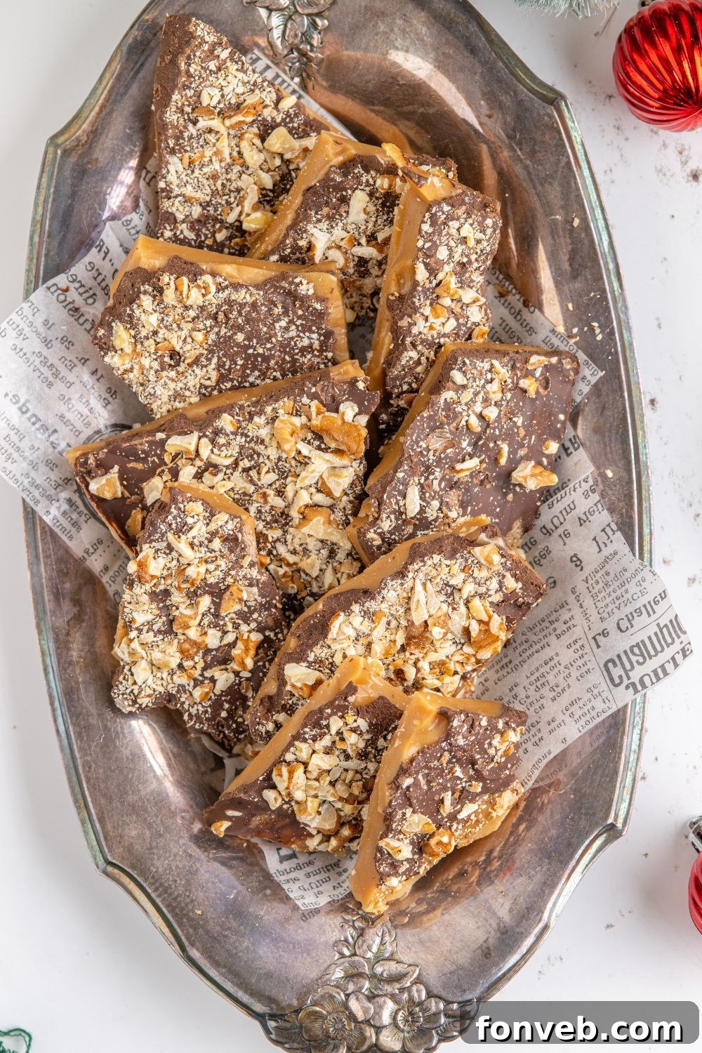English Toffee on a silver platter on table with a Christmas ornament to the side
