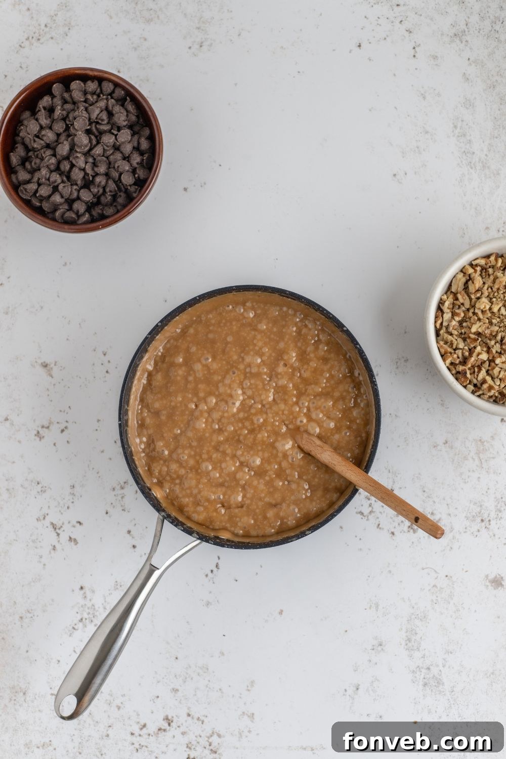 English Toffee being made in a saucepan with chocolate in a bowl to side on table 