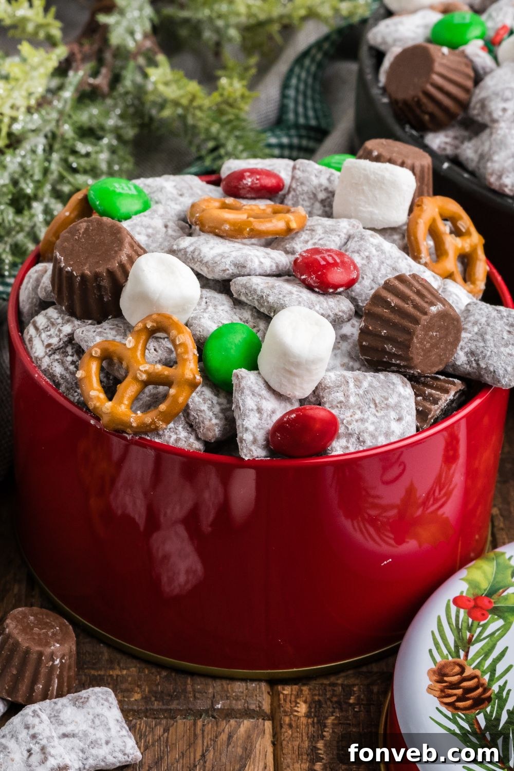 Christmas snack mix for gifts in a red tin on table with lid placed to the side