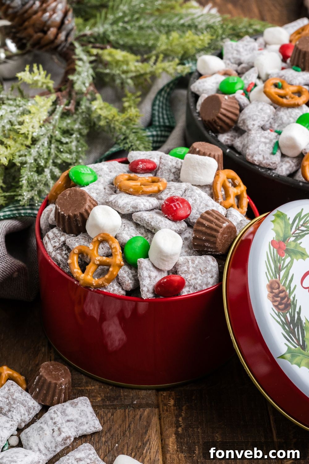 Christmas Chex Mix in bowls on table with Christmas tree limbs to side 