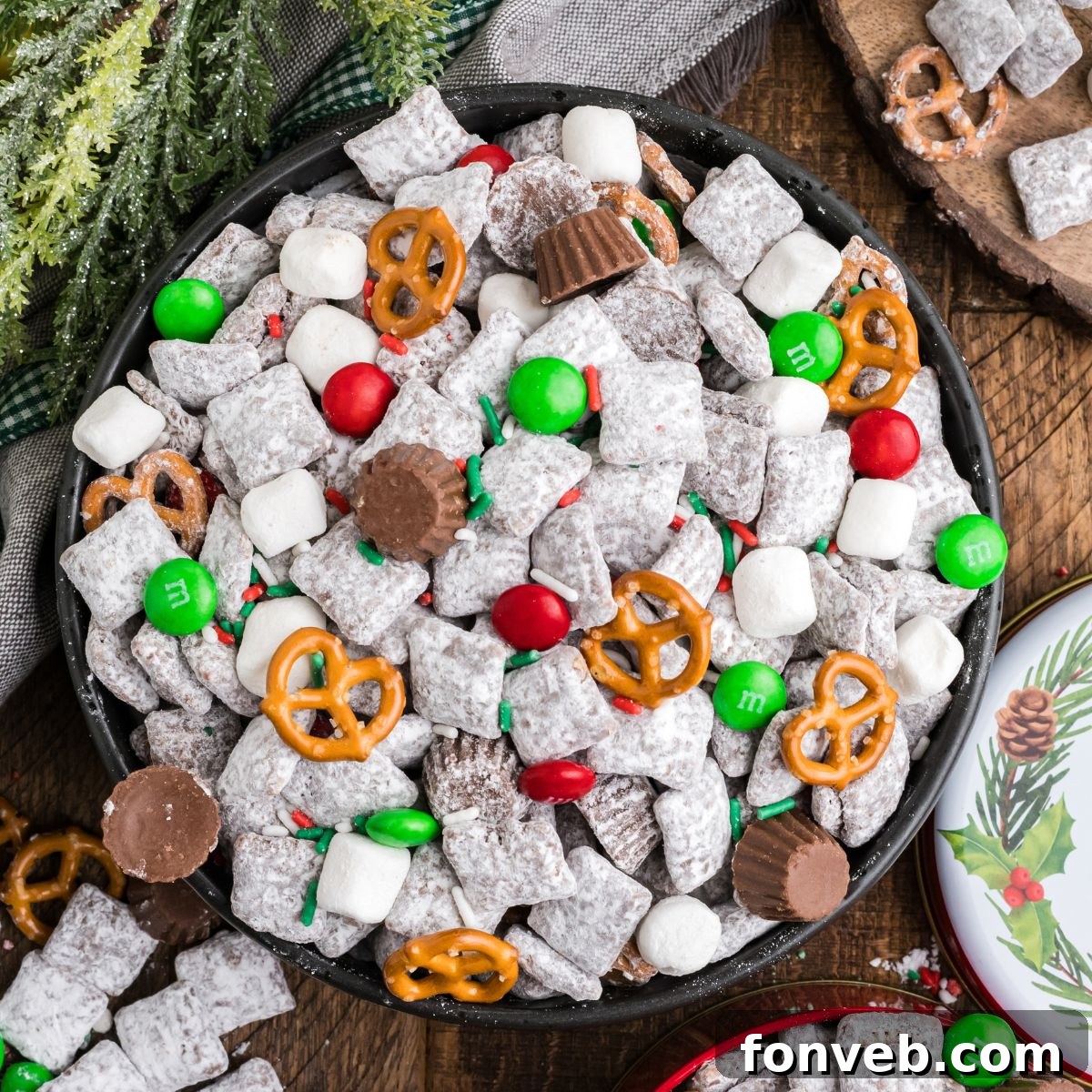 Christmas Chex Mix in a bowl loaded with candies and Christmas decor around table 