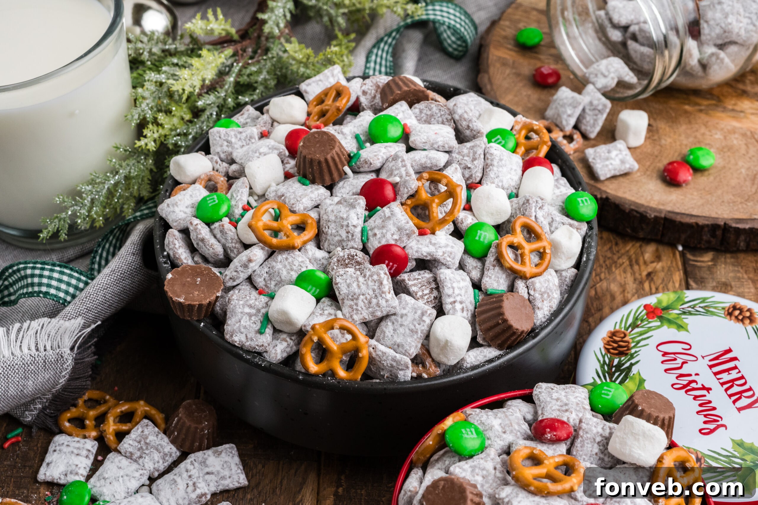view of a black bowl with Christmas Chex Mix and more puppy chow and toppings falling out of bowl 