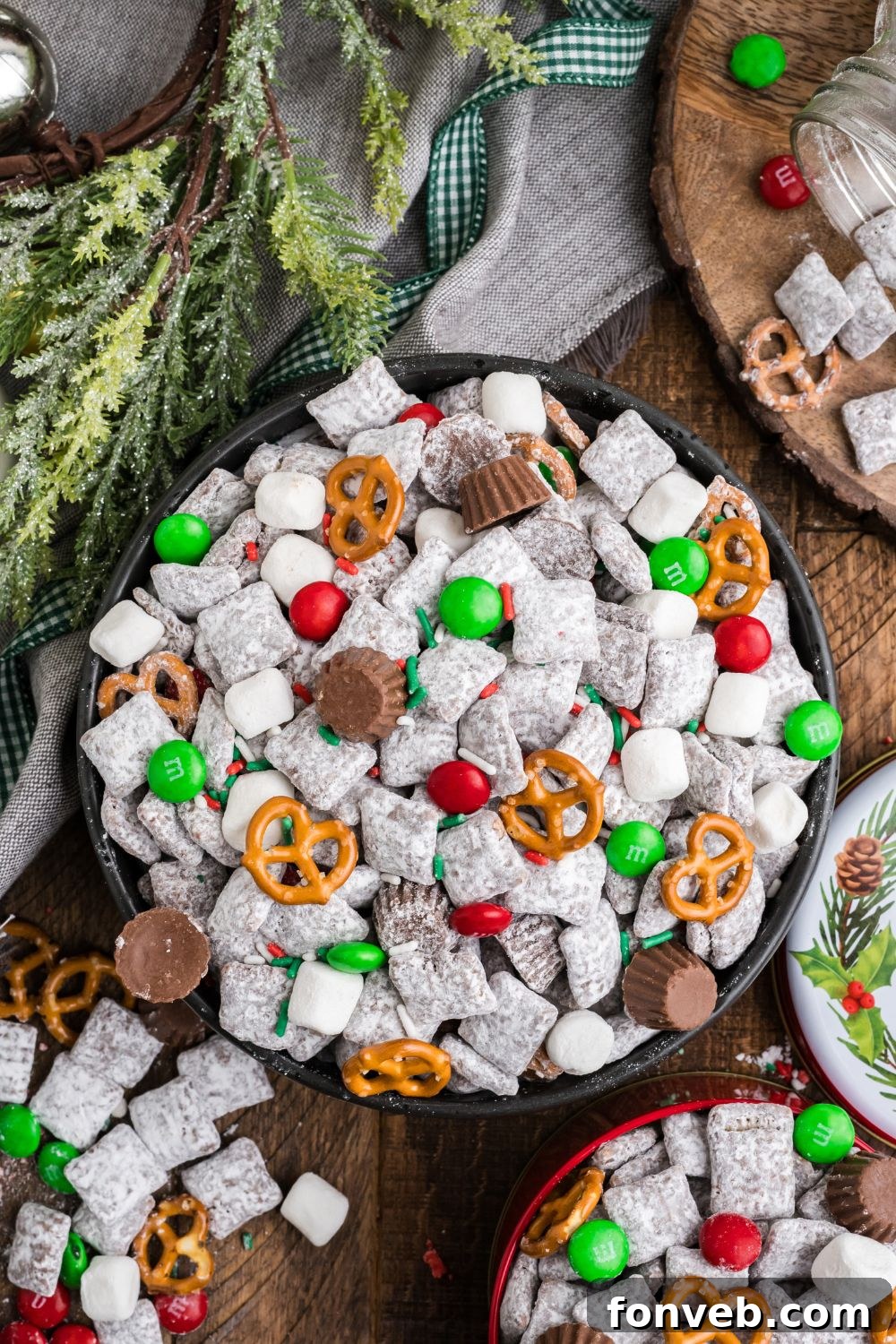 a blend of bowls of Christmas Chex Mix and a greenery around table 