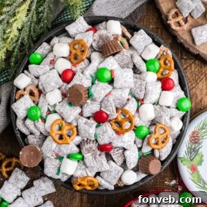 Christmas Chex Mix in a bowl loaded with candies and Christmas decor around table