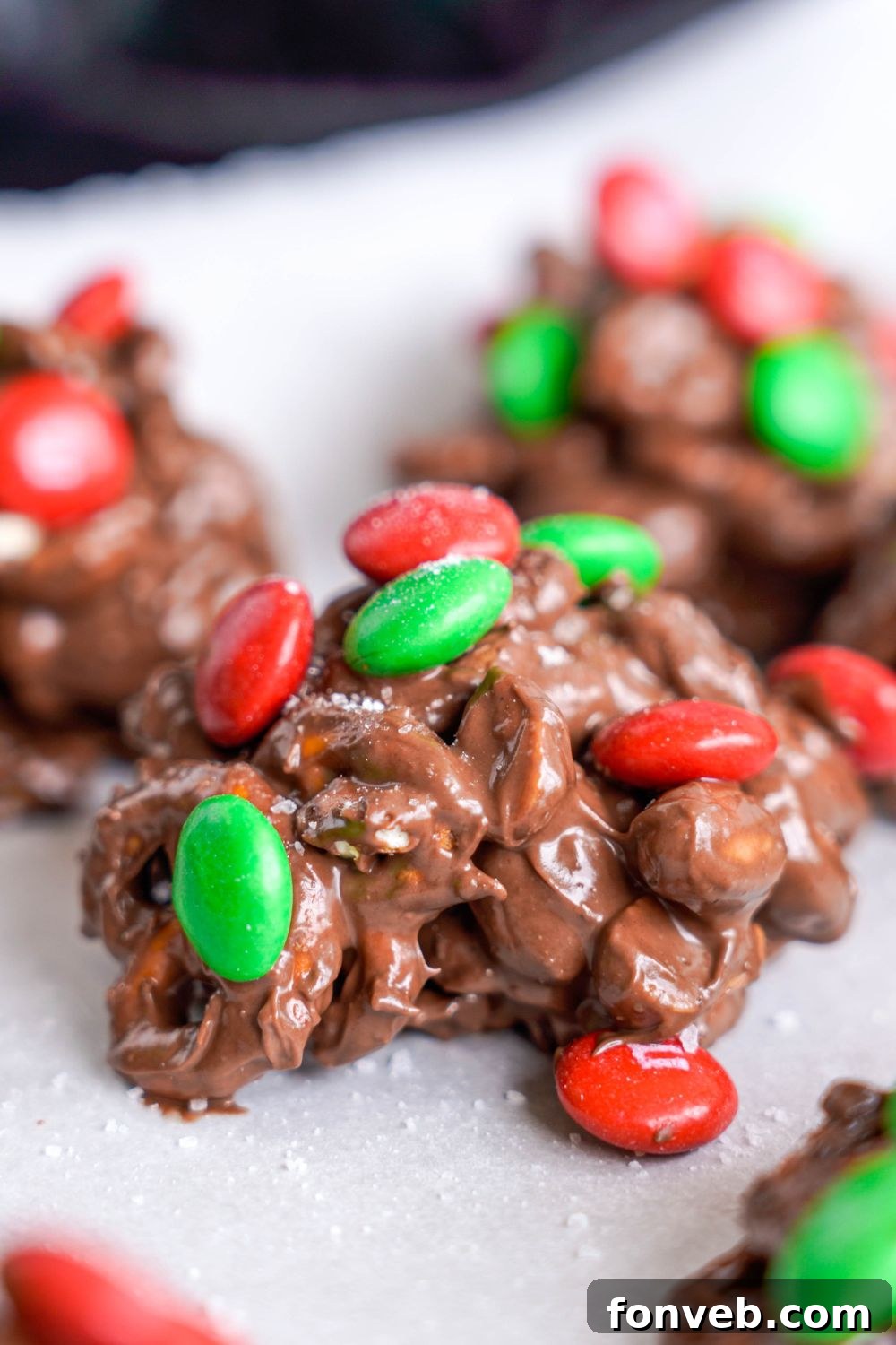 Sweet and Salty Slow Cooker Holiday Clusters 20 Crockpot Chocolate Pretzel Christmas Candy in piles on parchment paper