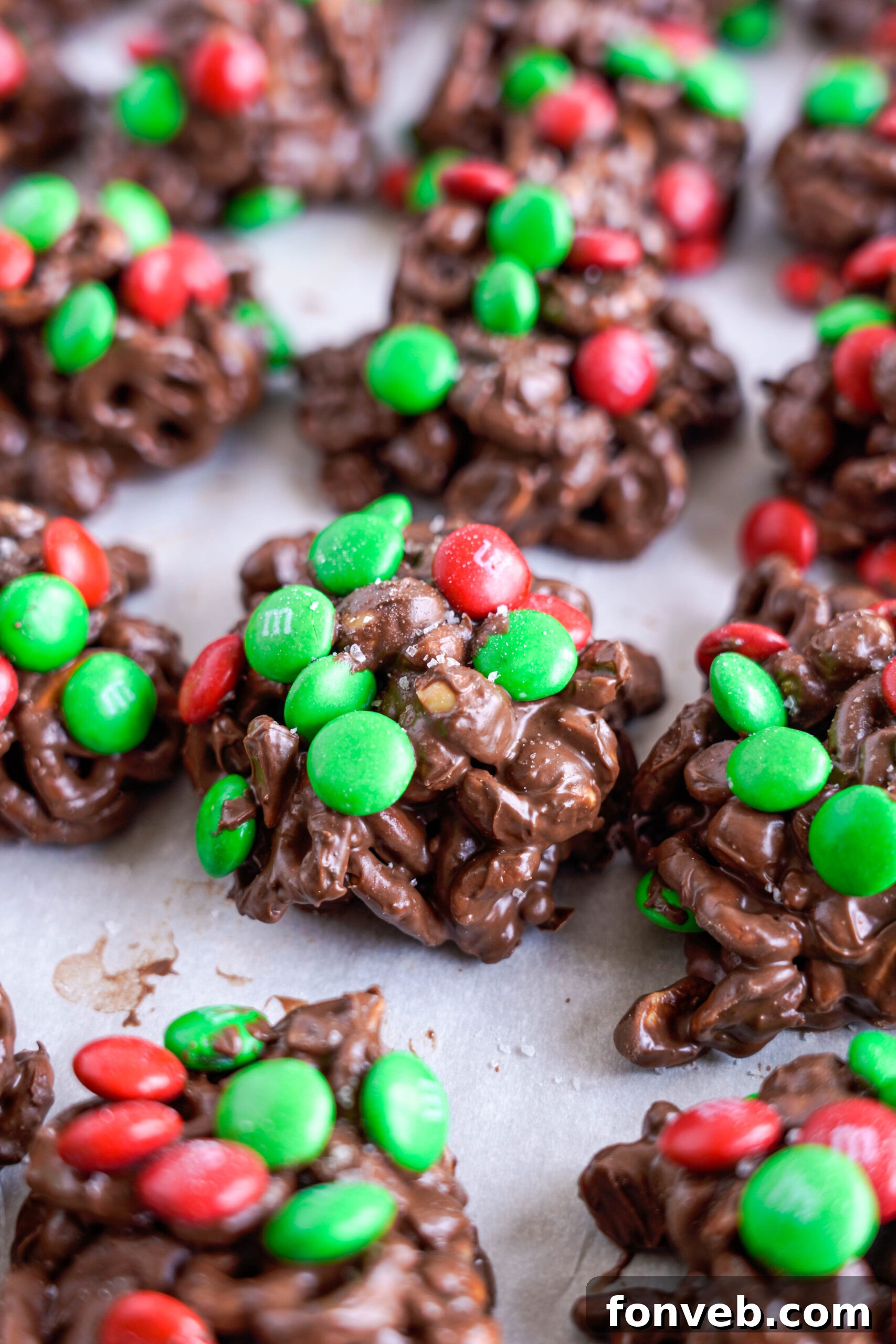 Sweet and Salty Slow Cooker Holiday Clusters 24 Crockpot Chocolate Pretzel Christmas Candy in a row on a baking sheet