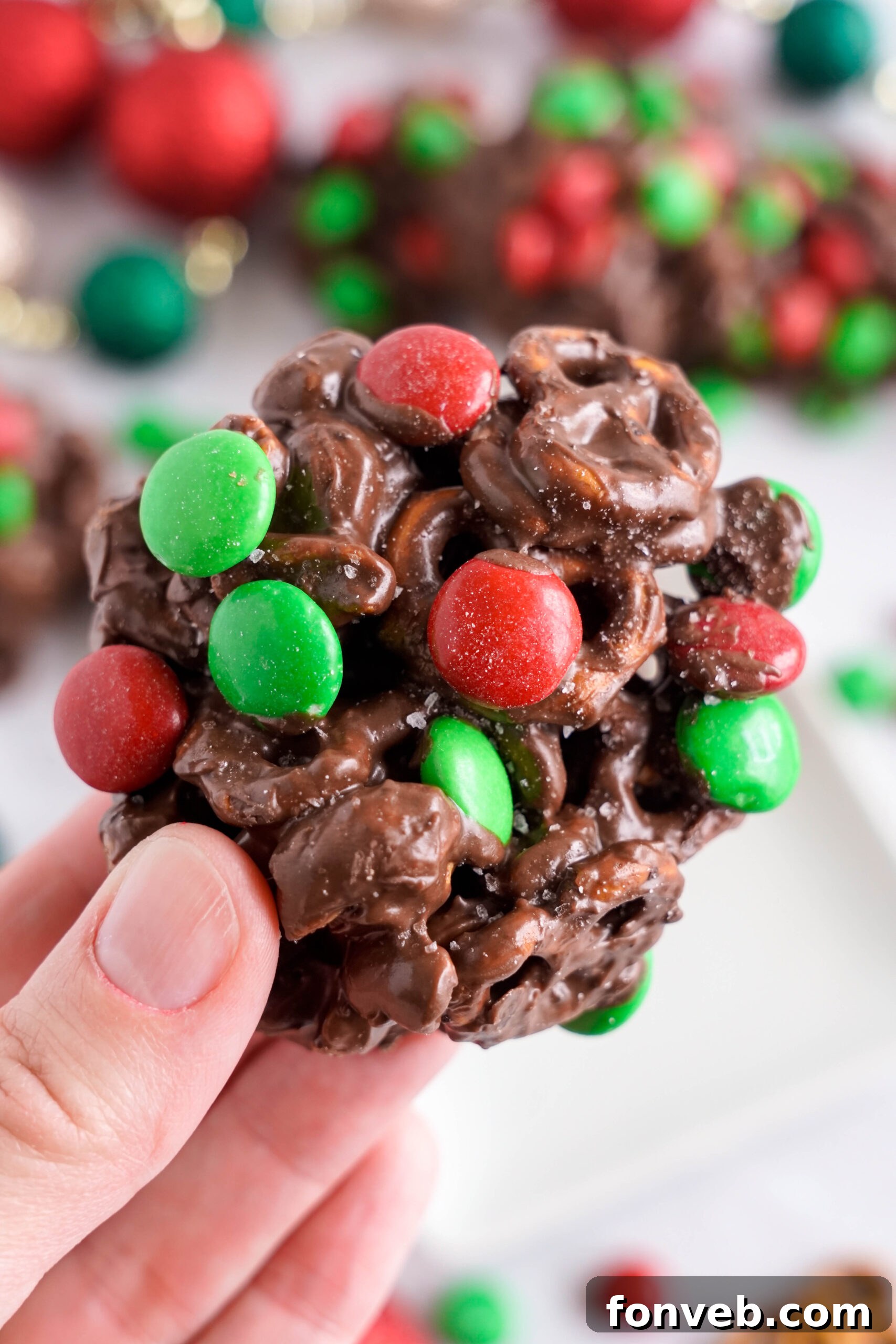 Sweet and Salty Slow Cooker Holiday Clusters 26 Crockpot Chocolate Pretzel Christmas Candy piece being held up