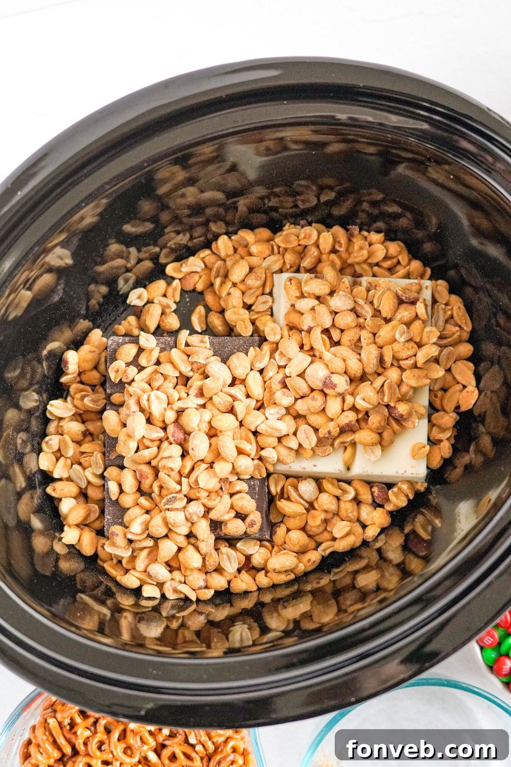 Sweet and Salty Slow Cooker Holiday Clusters 7 chocolate with nuts poured over the top of it