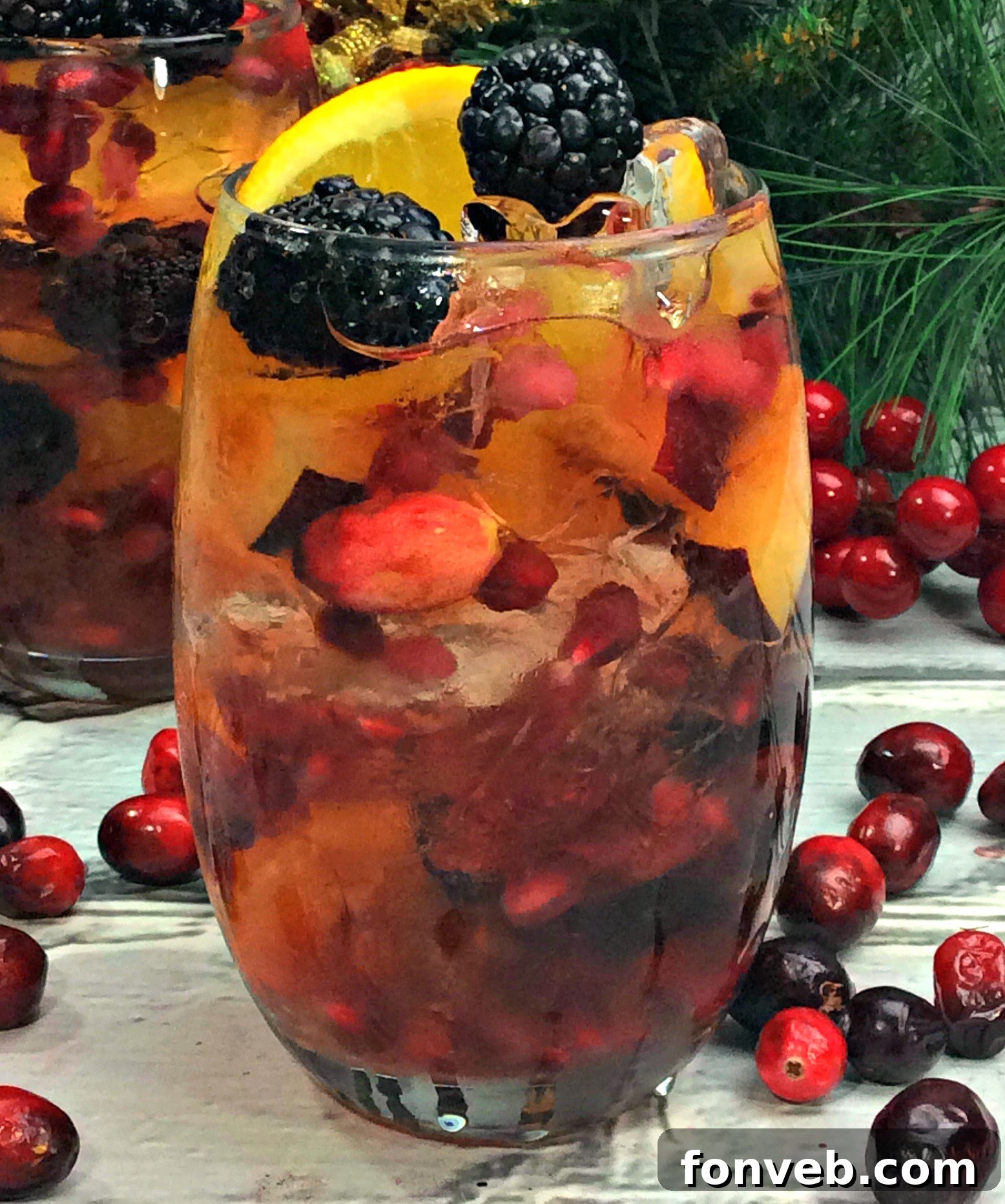 Pitcher of homemade white wine sangria with fresh blackberries, cranberries, and orange slices, ready to be served.