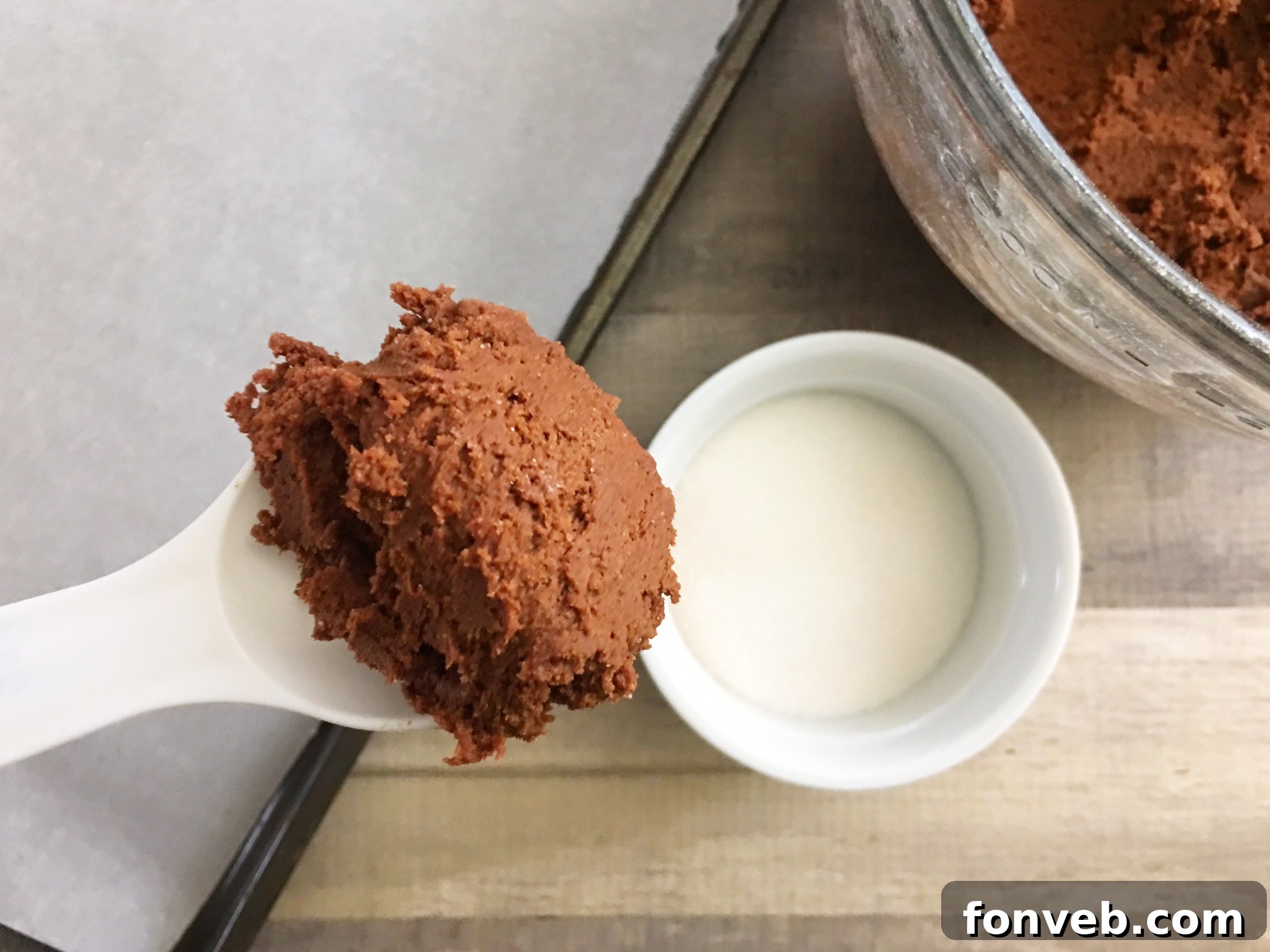 Close-up shot of several Hershey's Hugs Blossom Cookies resting on a wire cooling rack, highlighting their perfectly rounded shape, sugar-coated exterior, and the soft, slightly melted Hershey's Hug on top.