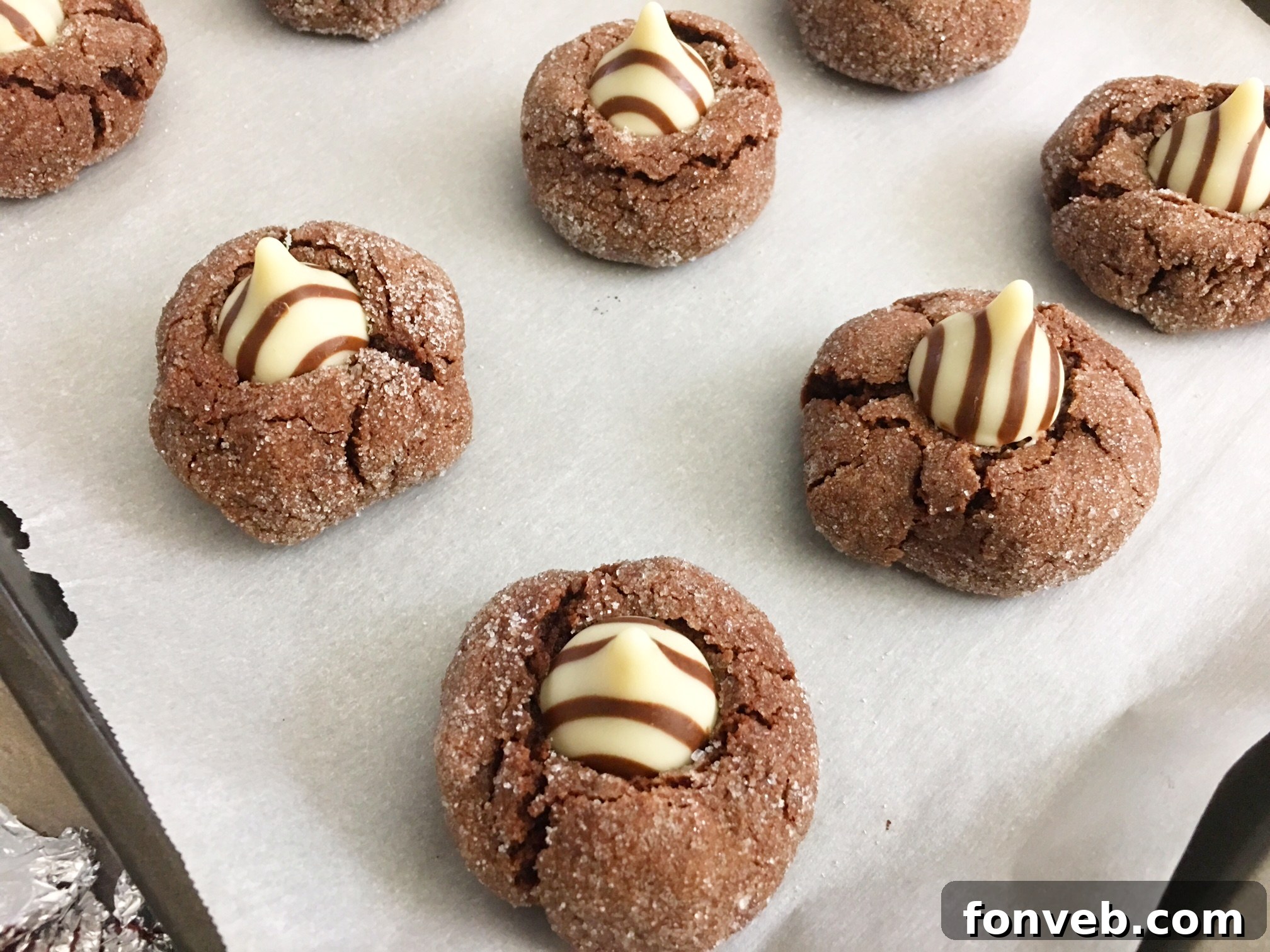 A single Hershey's Hugs Blossom Cookie, perfectly sugar-coated and featuring a distinct Hershey's Hug nestled in its soft chocolate center, presented in a close-up.