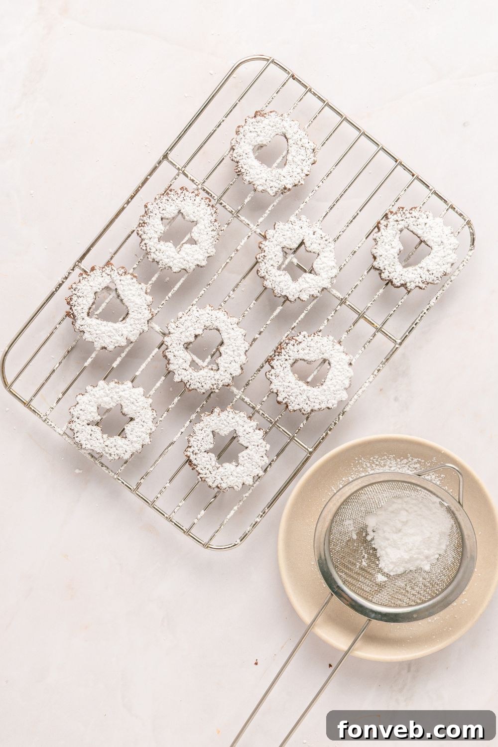 powdered sugar dusted chocolate linzer cookies shaped like stars 