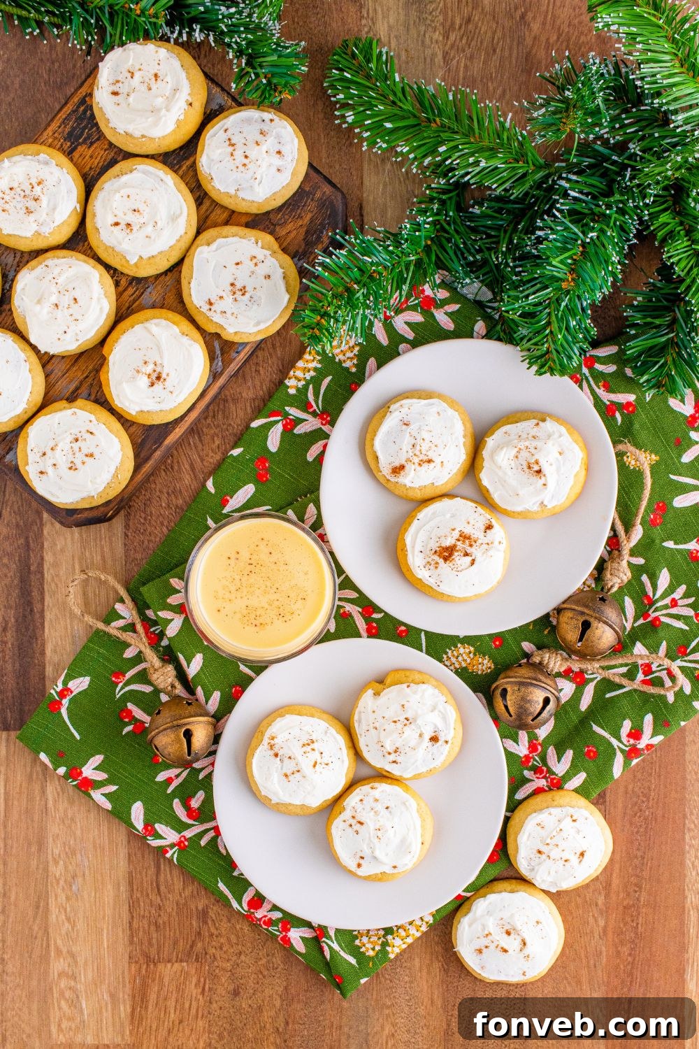 Soft Frosted Eggnog Cookies on plates on a table and a wooden table to side with more cookies