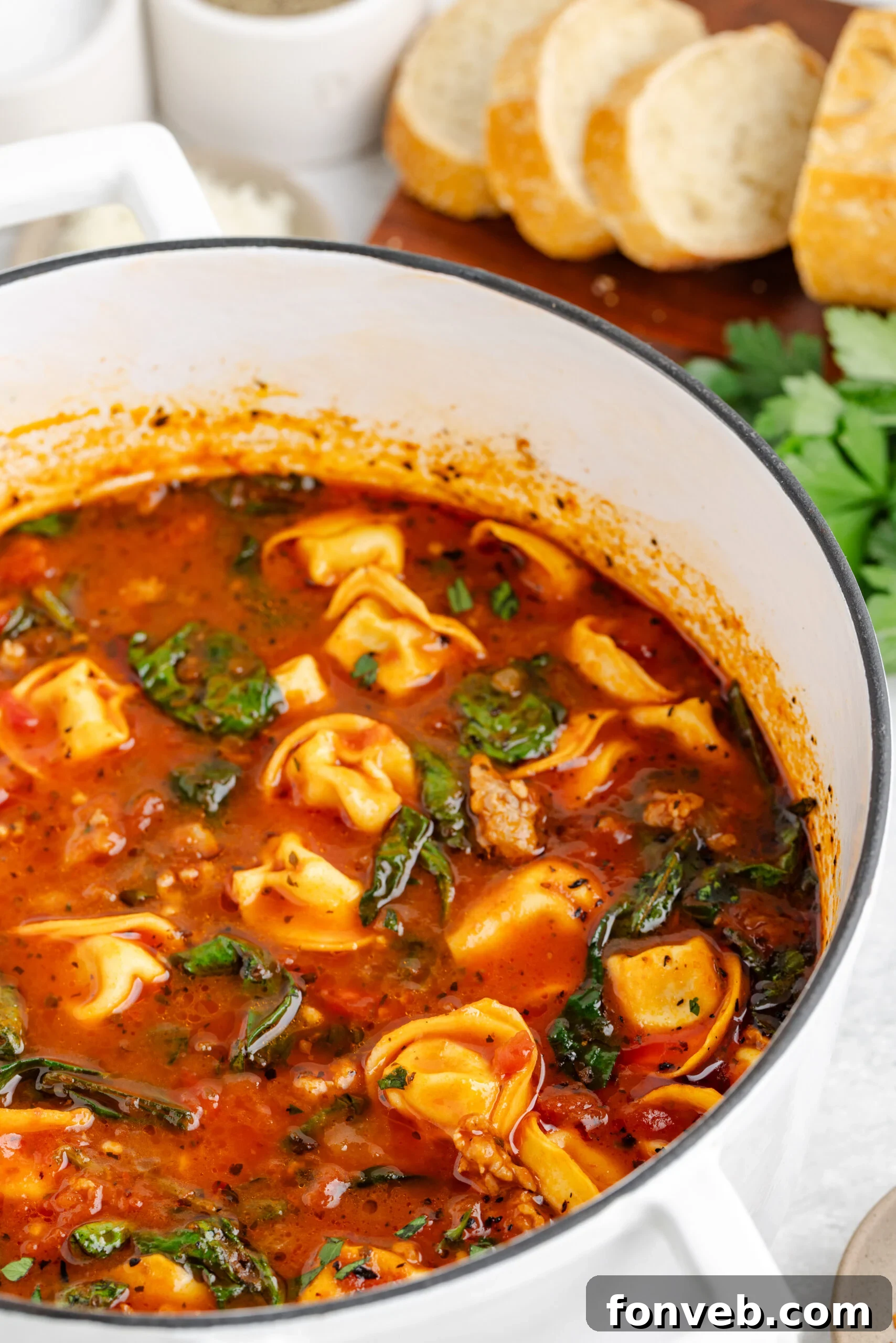 A large serving pot filled to the brim with rich and appetizing Sausage Tortellini Soup, ready to be enjoyed