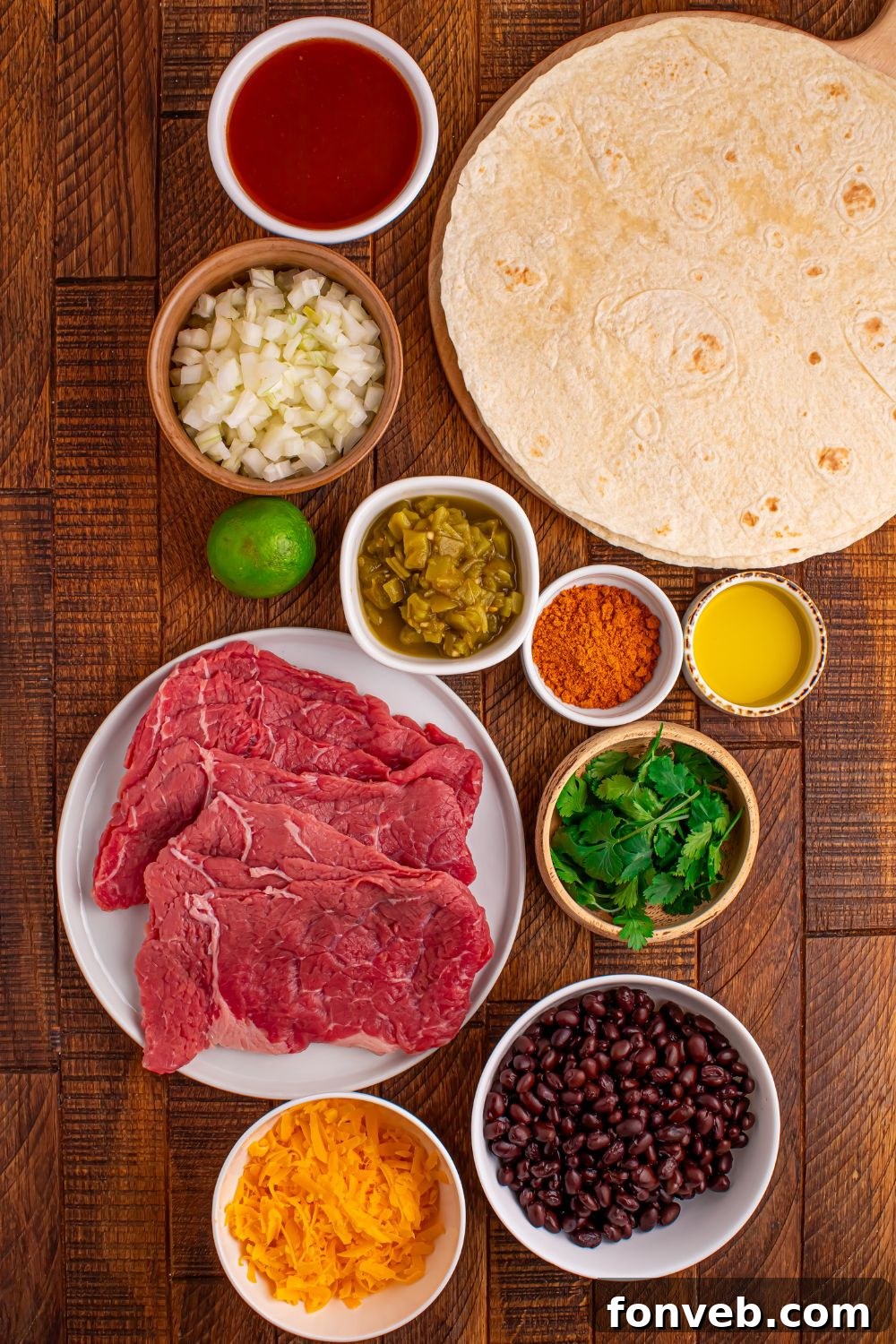 Steak Enchilada ingredients all placed on the table in bowls to show all the ingredients you will need to make the dish 