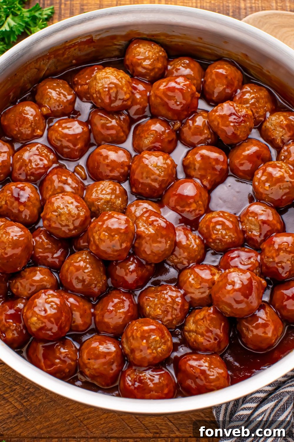 overhead look of a skillet on table with a skillet full of Peach BBQ Meatballs
