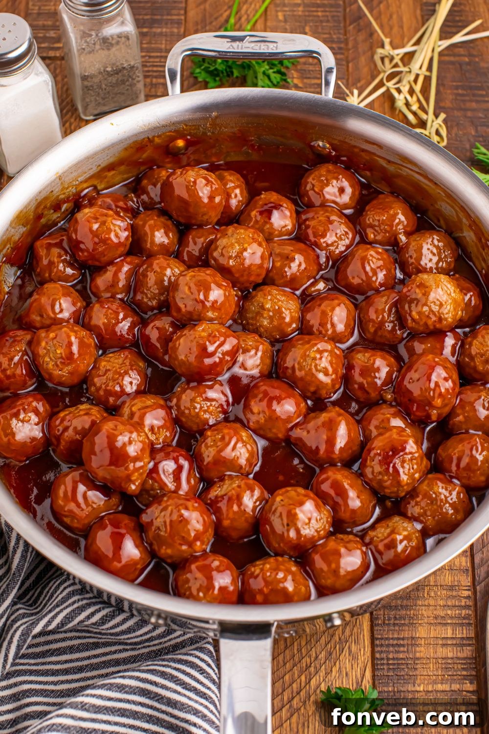 skillet full of Peach BBQ Meatballs on a wooden table 