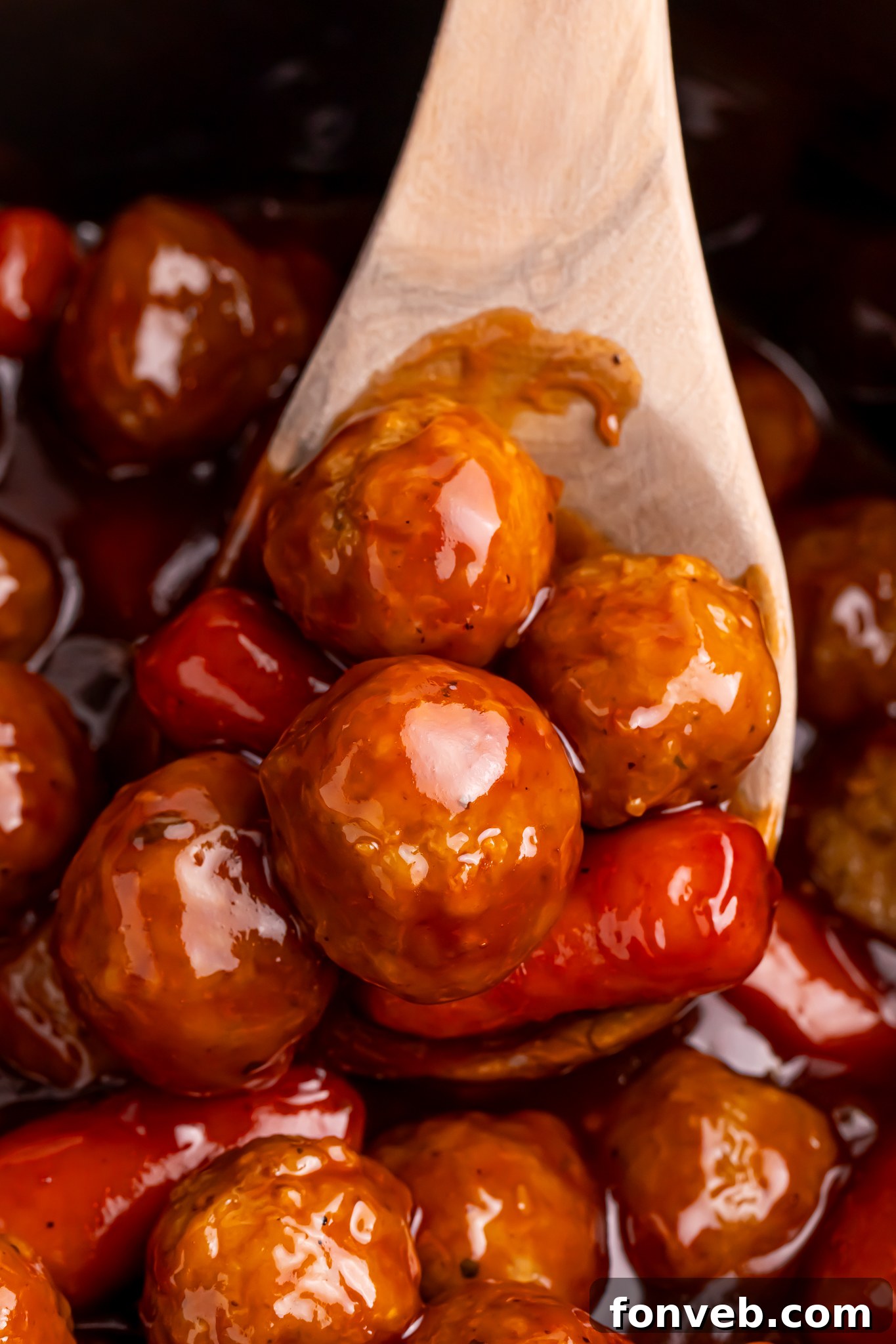 Crockpot Teriyaki BBQ Cocktail Meatballs & Lil Smokies being lifted up by a wooden spoon 
