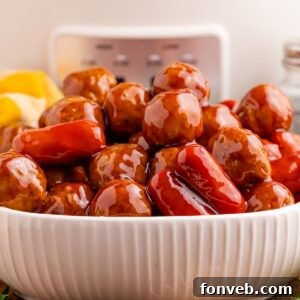 Crockpot Teriyaki BBQ Cocktail Meatballs & Lil Smokies in a white bowl on table with a crockpot behind it