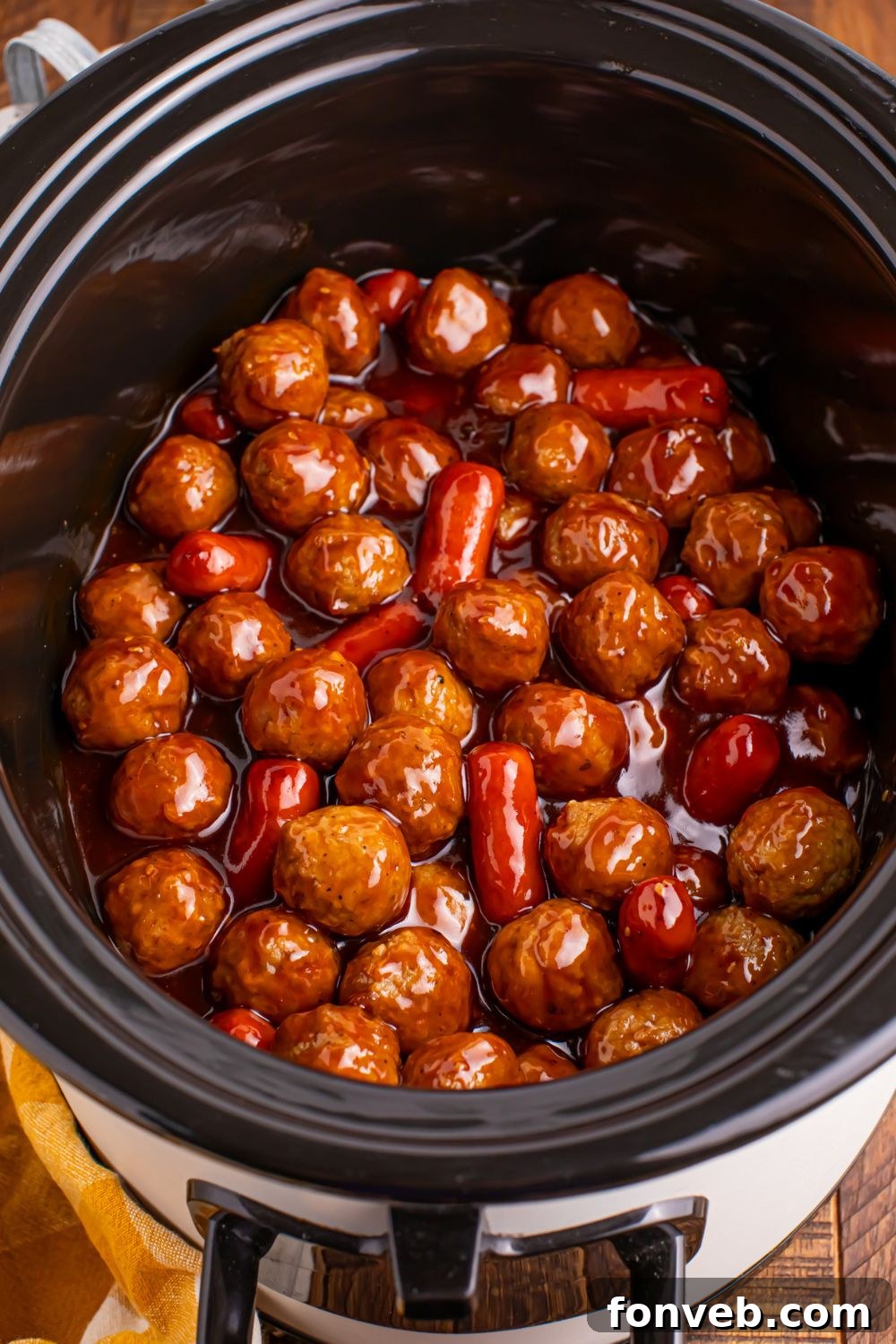 looking down on table and you see a crockpot full of teriyaki meatballs and lil smokies 